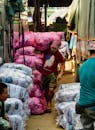 Man Carrying Large Pink Sack in Bustling Market