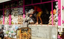 Workers Loading Vegetable Bags onto Truck