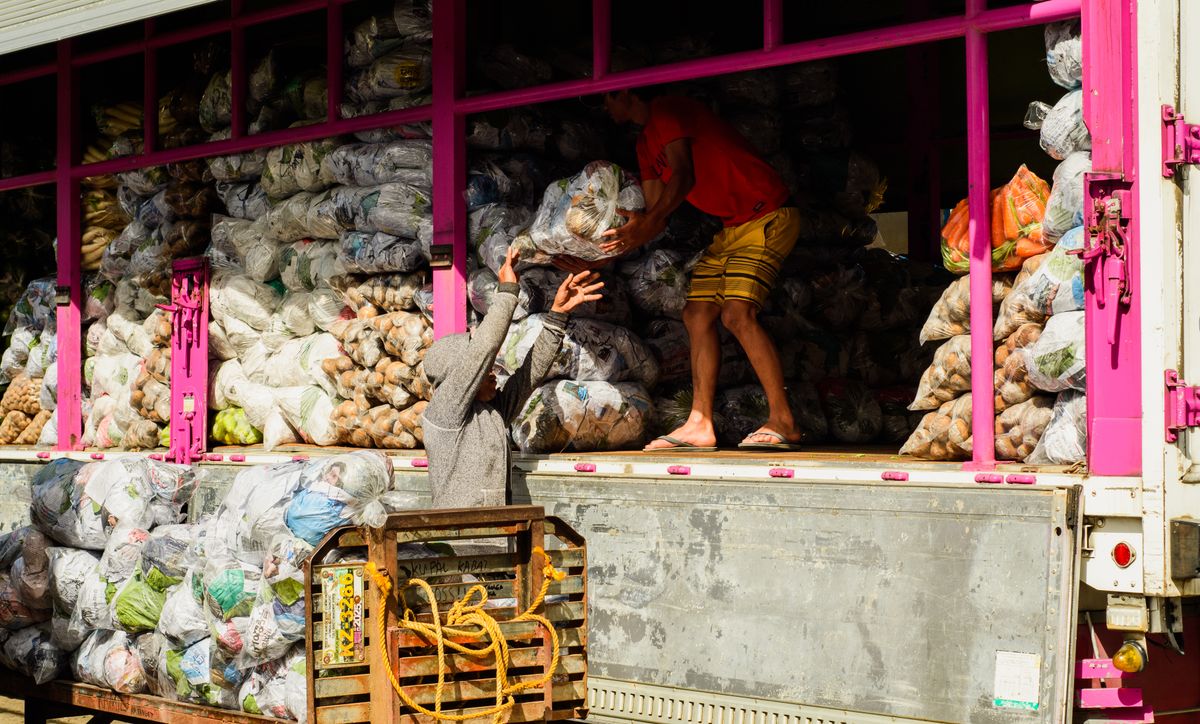 Lori dimuatkan dengan guni hasil segar untuk penghantaran borong