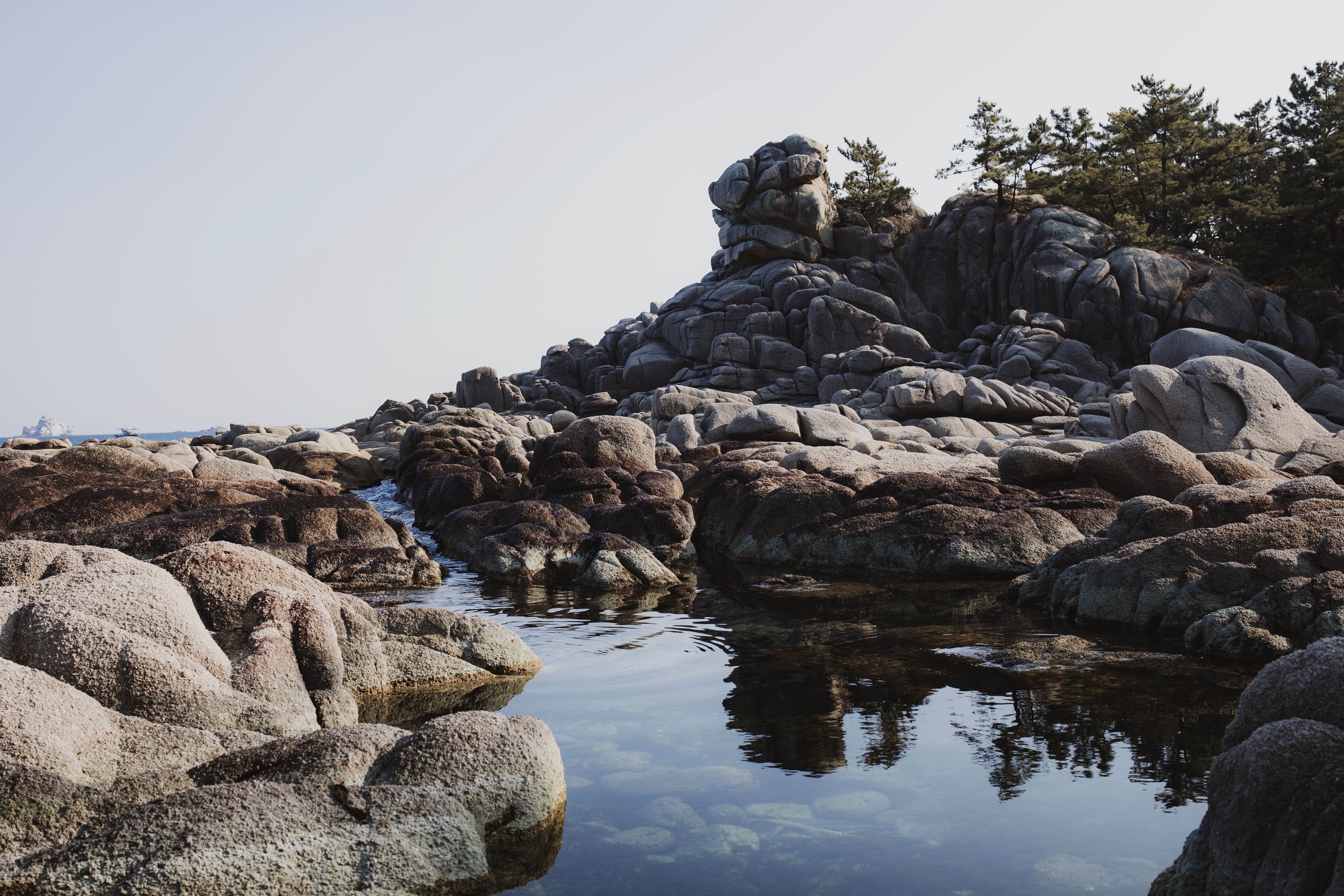 Tranquil scene of coastal rock formations and reflecting water in Gangwon, South Korea.