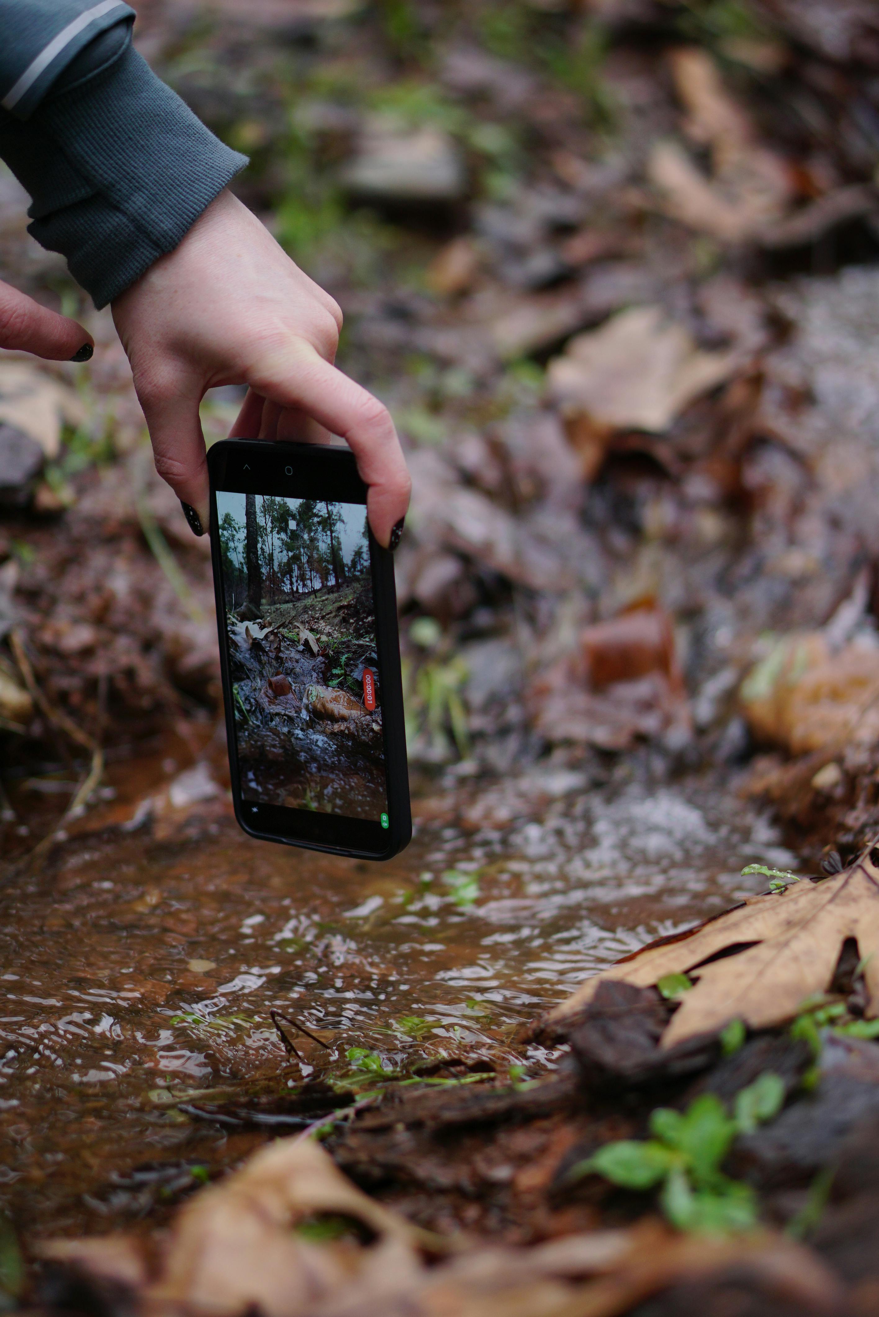 gratis Een hand die een telefoon vasthoudt en een beekje filmt in Kahramanmaraş, Turkije. Stockfoto