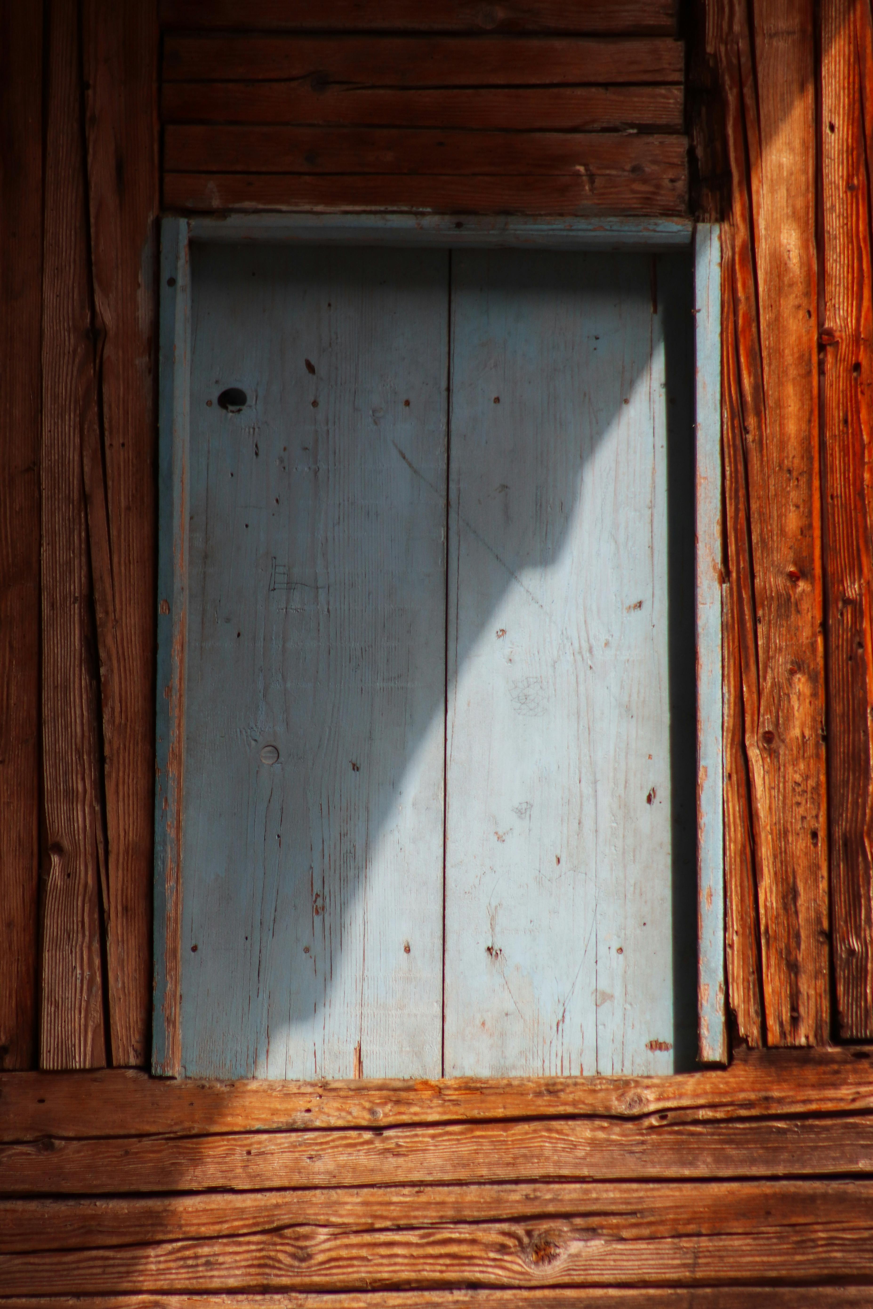 Gratis Una puerta de madera rústica con pintura azul descolorida, que proyecta una sombra bajo la brillante luz del sol. Foto de stock
