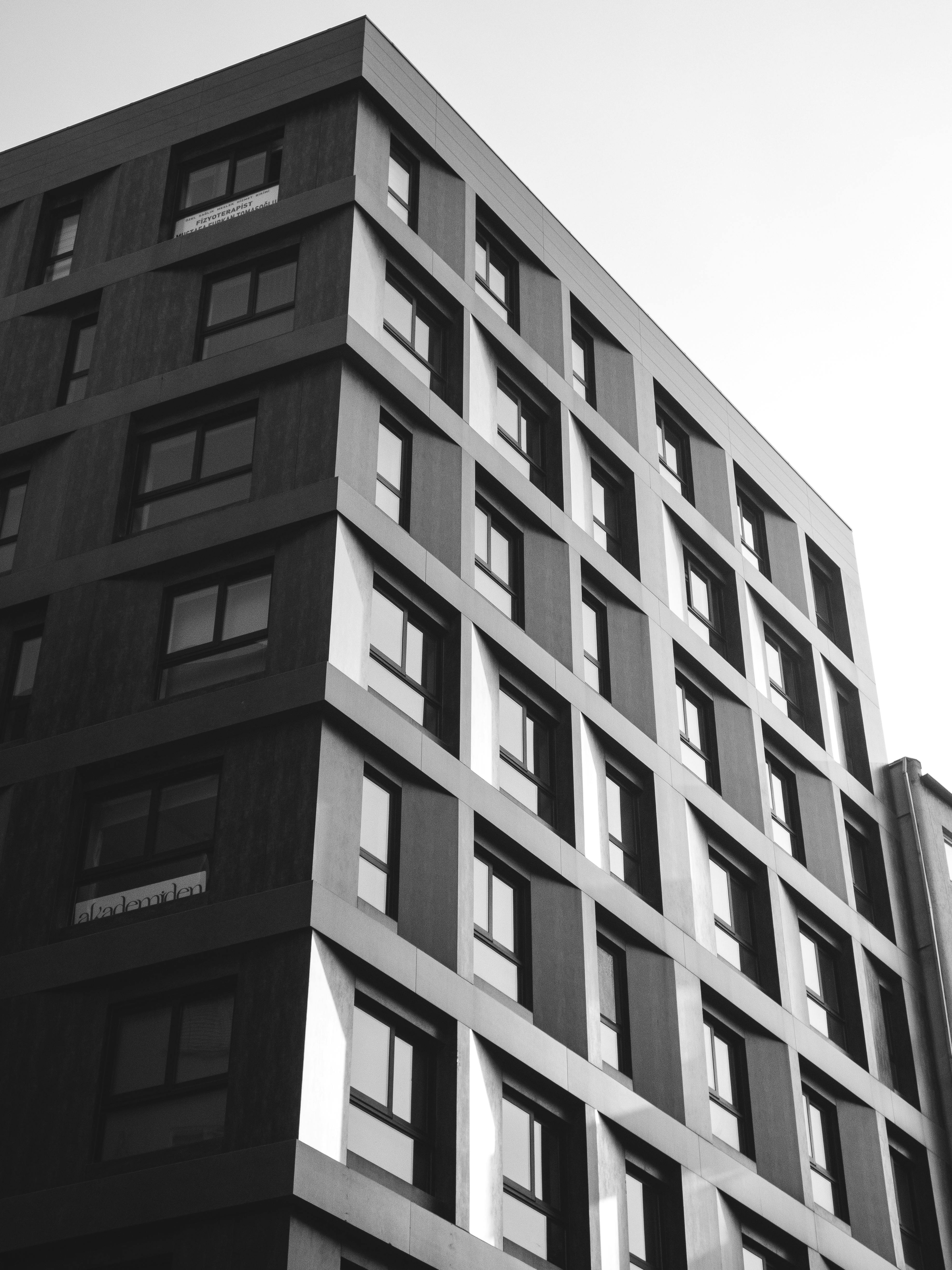 Kostenlos Schwarzweißfoto eines modernen Apartmentgebäudes mit kantiger Architektur. Stock-Foto