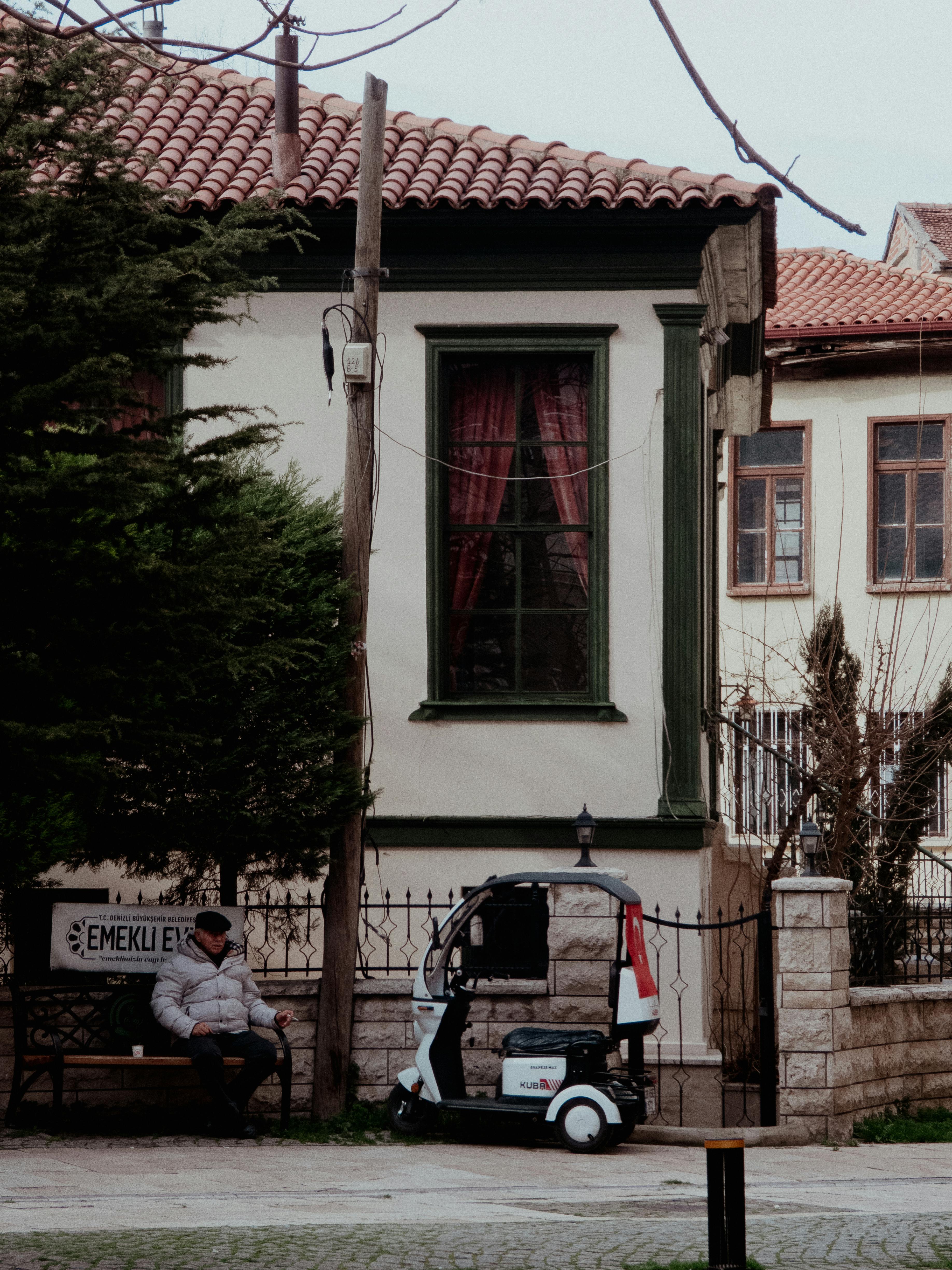 Miễn phí Một người đang thư giãn bên ngoài một ngôi nhà truyền thống với điểm nhấn màu đỏ vào một ngày mùa đông. Ảnh lưu trữ