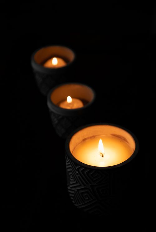 Free Three soothing candles in patterned black holders create a warm, relaxing ambiance. Stock Photo