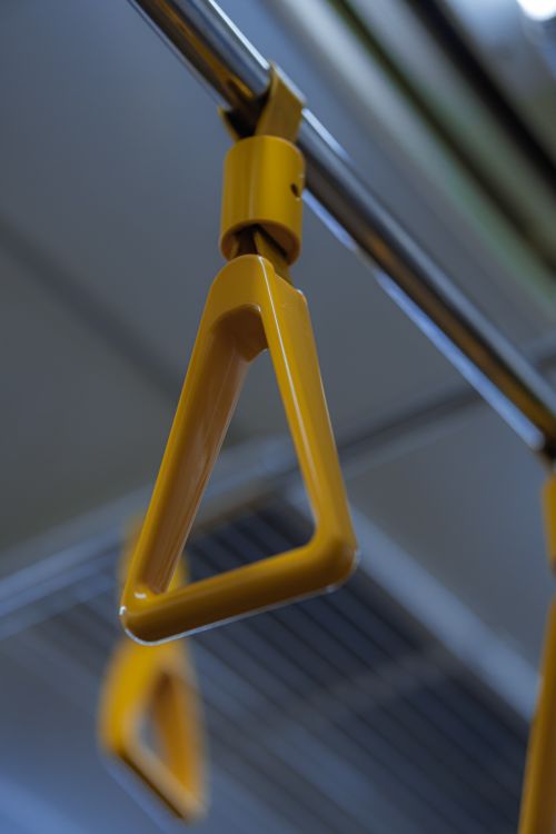 Free Close-up of a yellow hand strap on a subway rail, highlighting urban commute essentials. Stock Photo