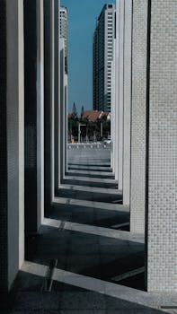 An abstract view of urban architecture featuring geometric shadows and towering skyscrapers.
