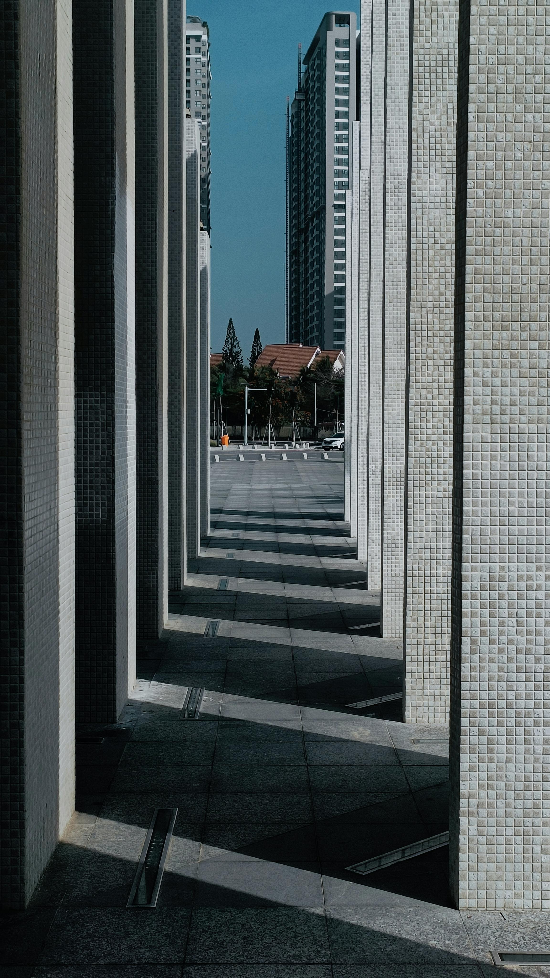 Kostenlos Eine abstrakte Ansicht urbaner Architektur mit geometrischen Schatten und hoch aufragenden Wolkenkratzern. Stock-Foto
