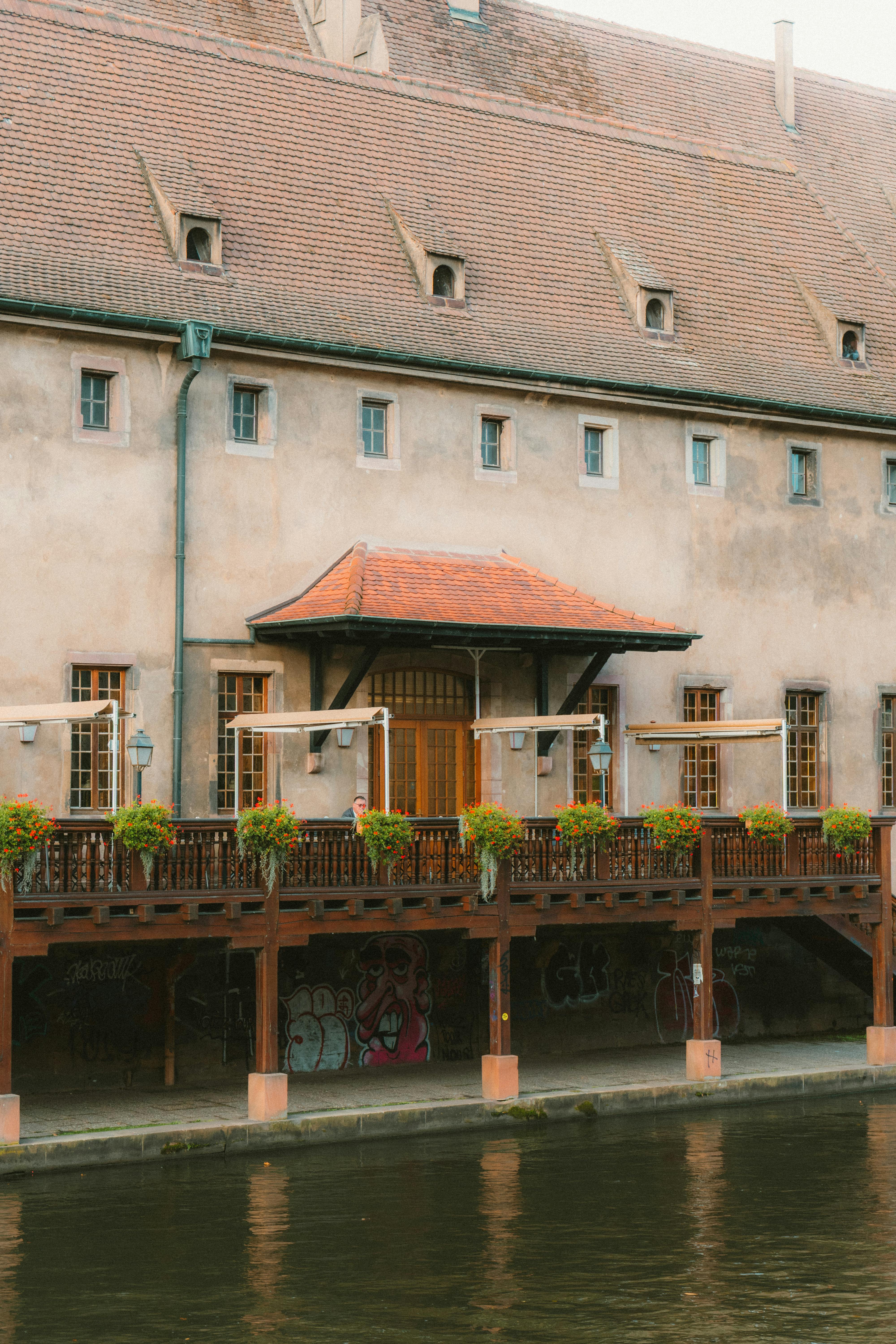 무료 프랑스 스트라스부르에 있는 매력적인 역사적인 건물로, 소박한 건축 양식과 생동감 넘치는 꽃 장식이 돋보입니다. 스톡 사진