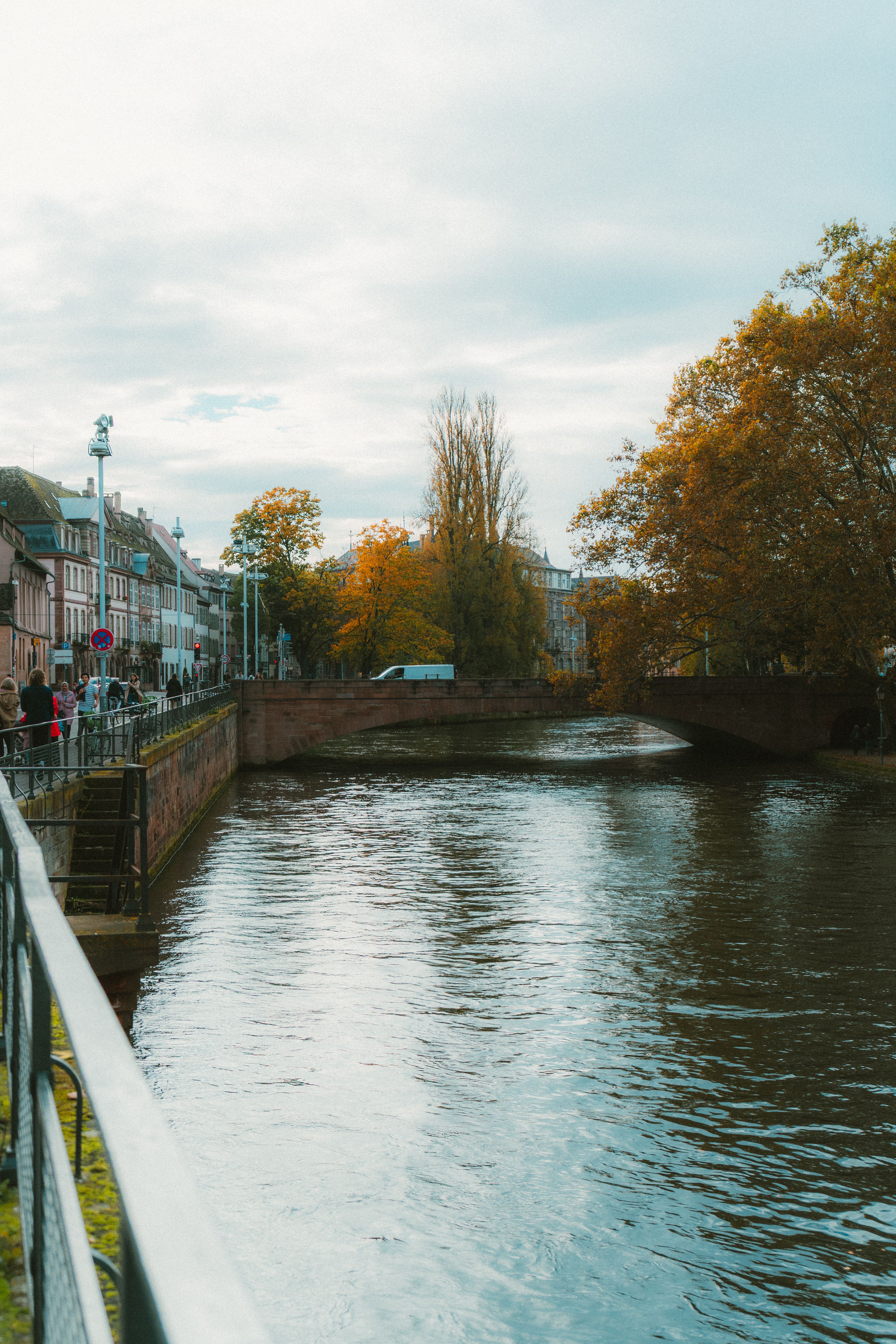 Canal de Strasbourg en automne, feuillages colorés et pont de pierre, sans passage.