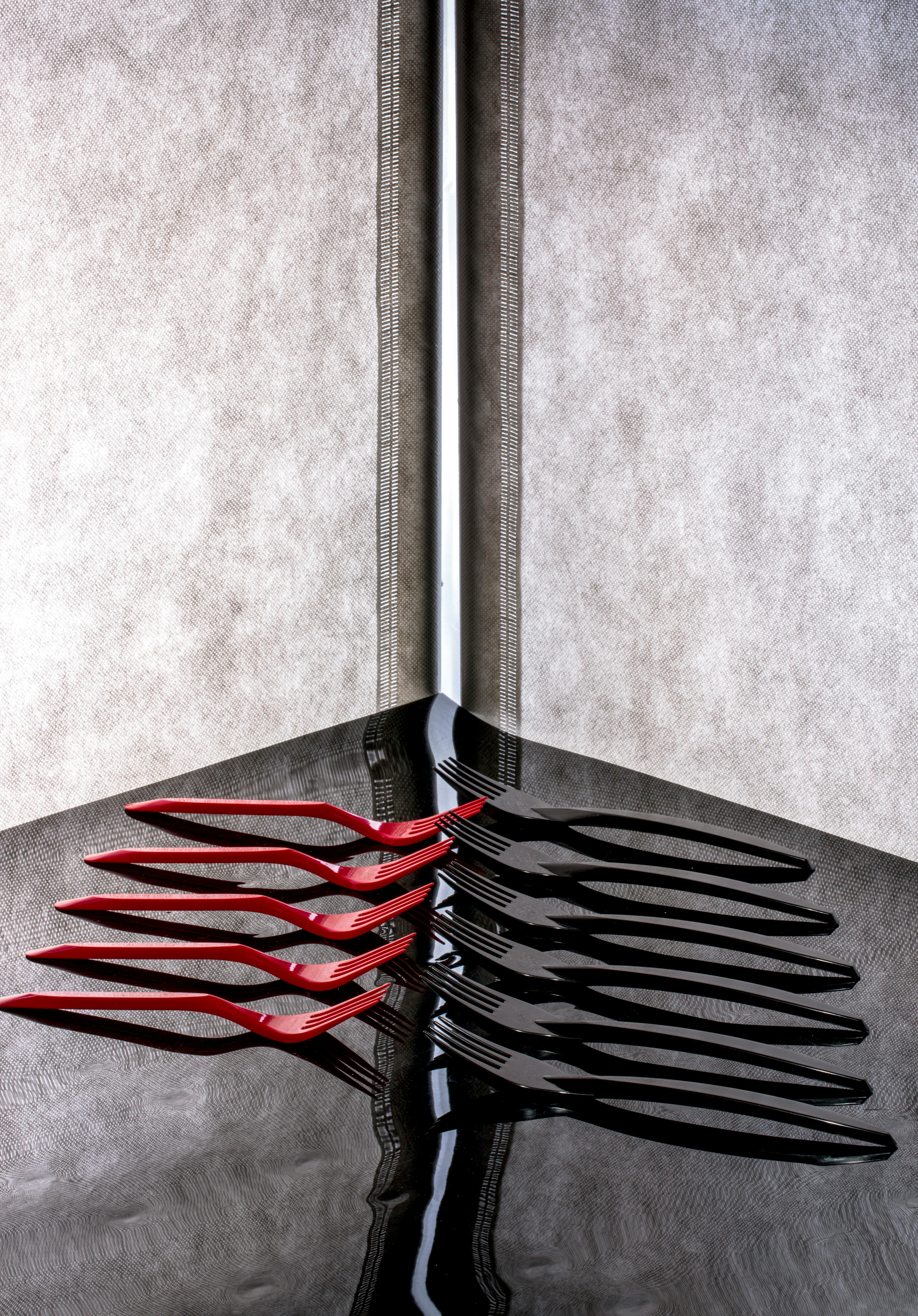 ingyenes Absztrakt dizájn piros és fekete villákkal, amelyek tükröződő felületen tükröződnek, szimmetriát teremtve. Stockfotó