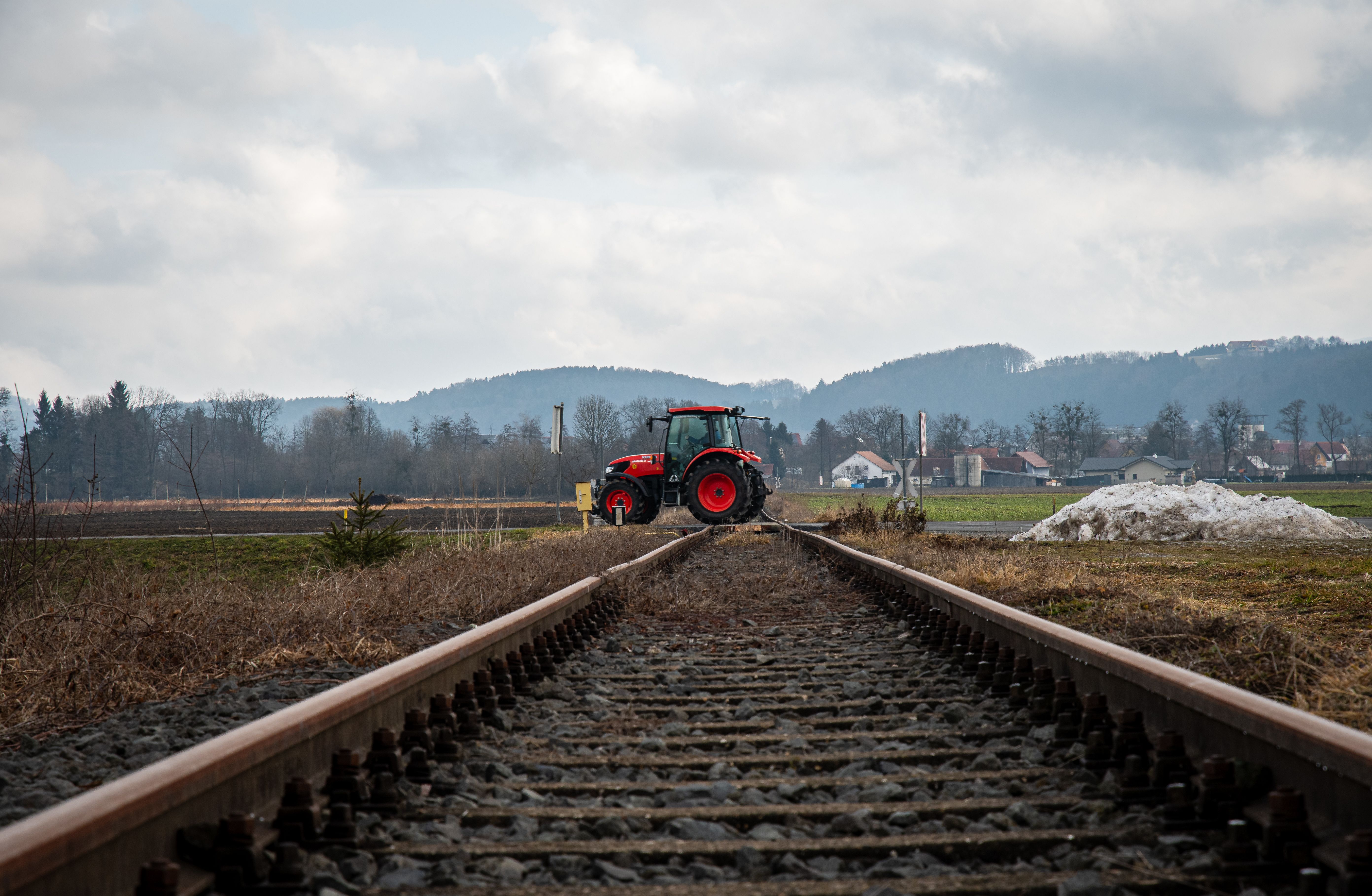 Tractor Crossing Railway Tracks in Rural Landscape · Free Stock Photo