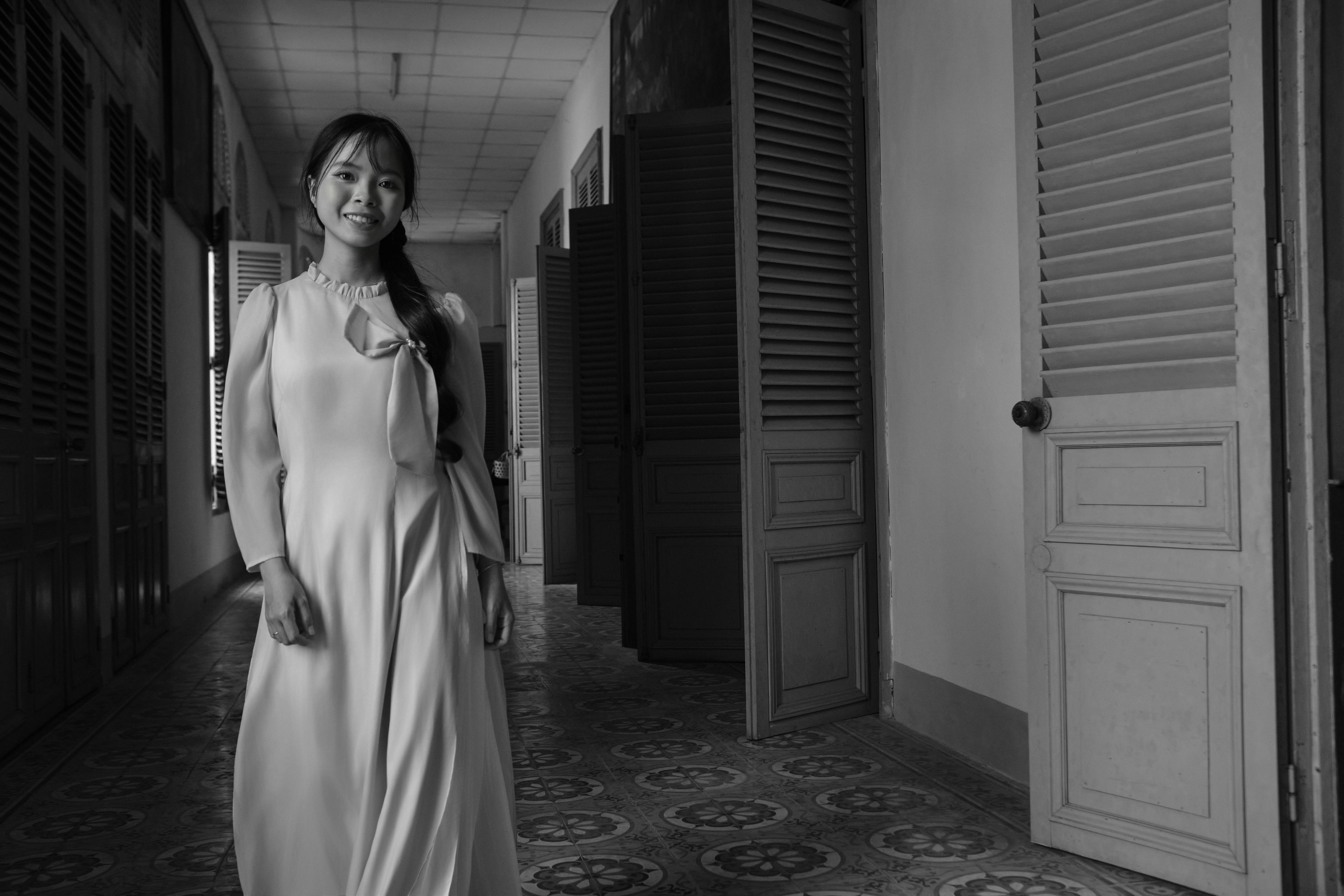 Black and white photo of a woman in an Ao Dai, showcasing elegance and traditional Vietnamese culture.