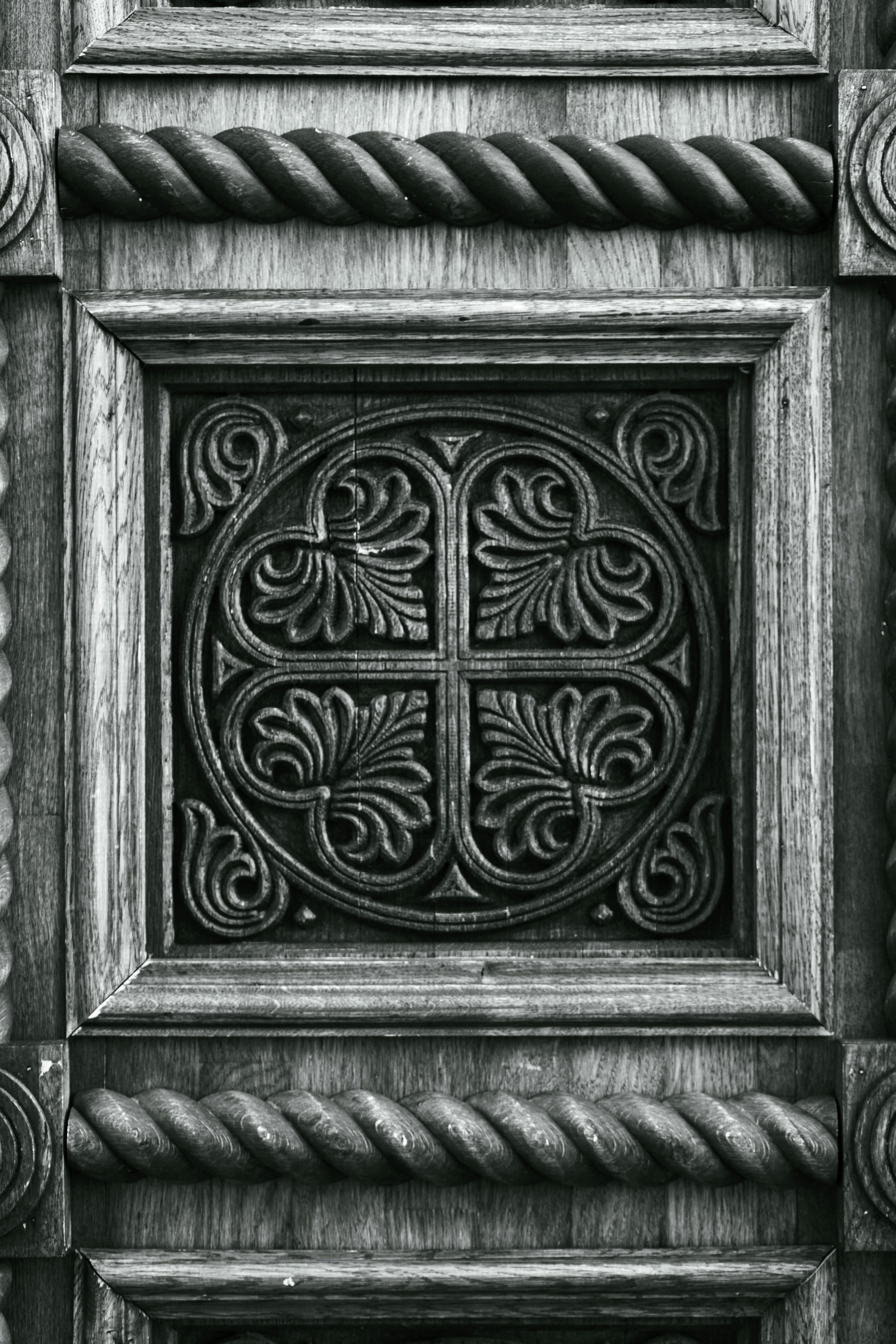 Kostnadsfria Svartvit närbild av en intrikat snidad trädörrpanel med utsmyckade detaljer. Stock foto