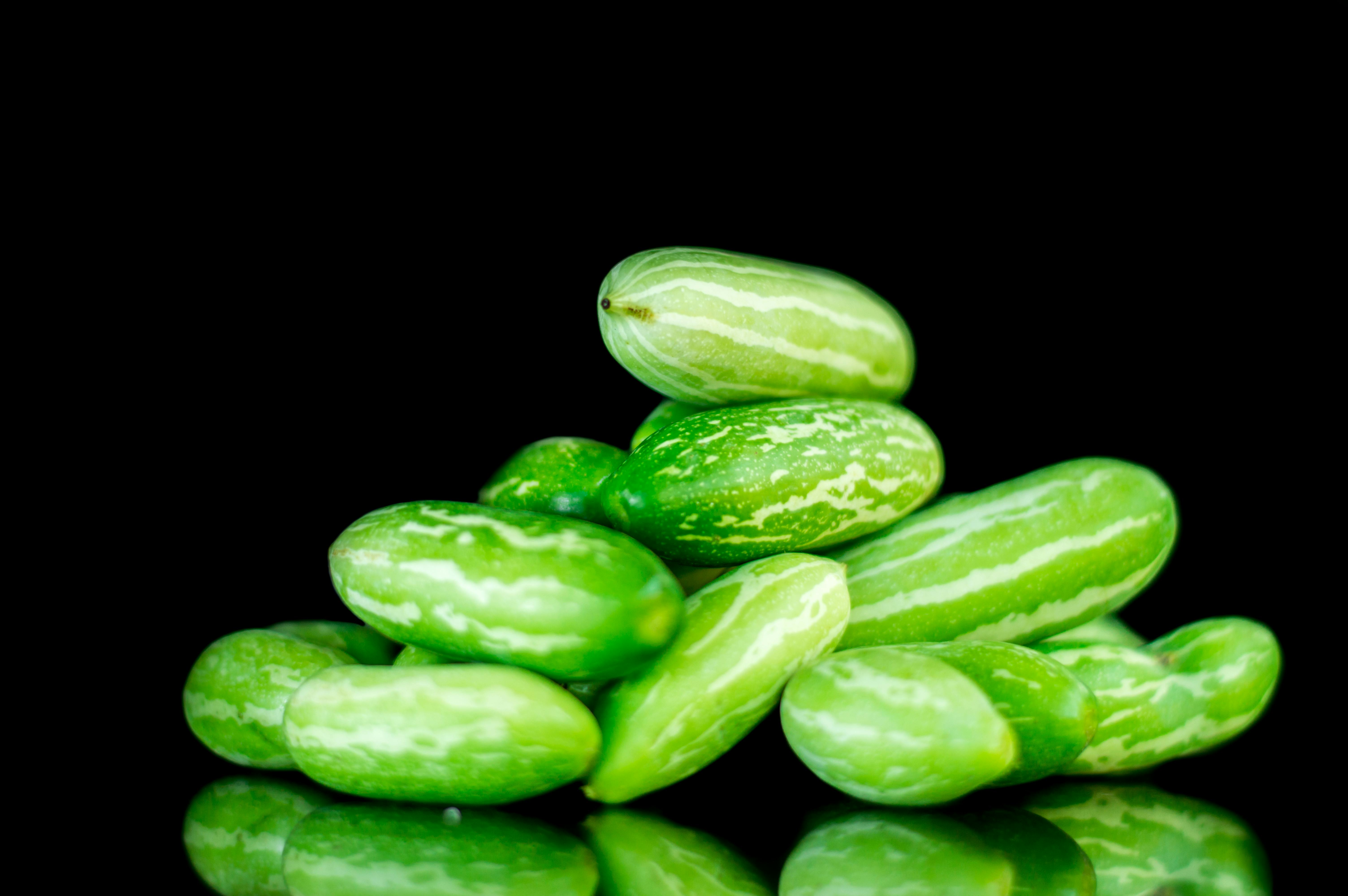 Miễn phí Cận cảnh những quả bầu leo ​​tươi xếp chồng lên nhau trên nền đen, làm nổi bật màu sắc rực rỡ của chúng. Ảnh lưu trữ