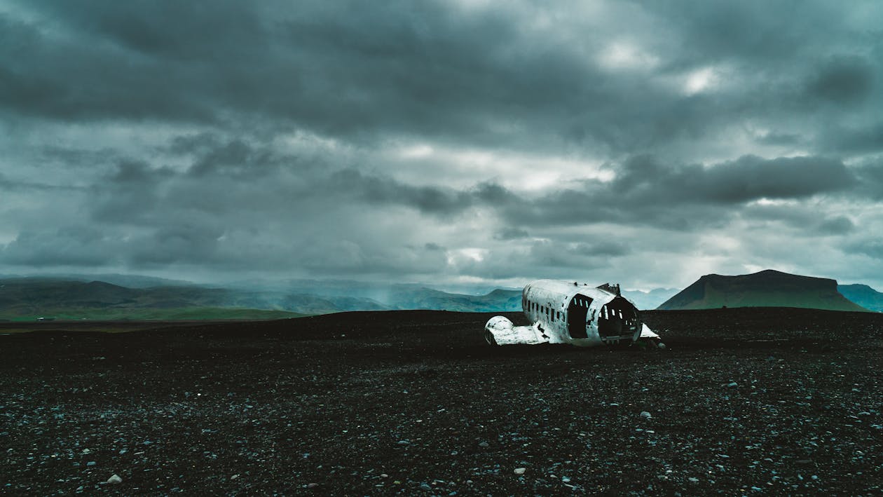 Airplane Wreck in Black Sand Under Gray Cloudy Sky · Free Stock Photo
