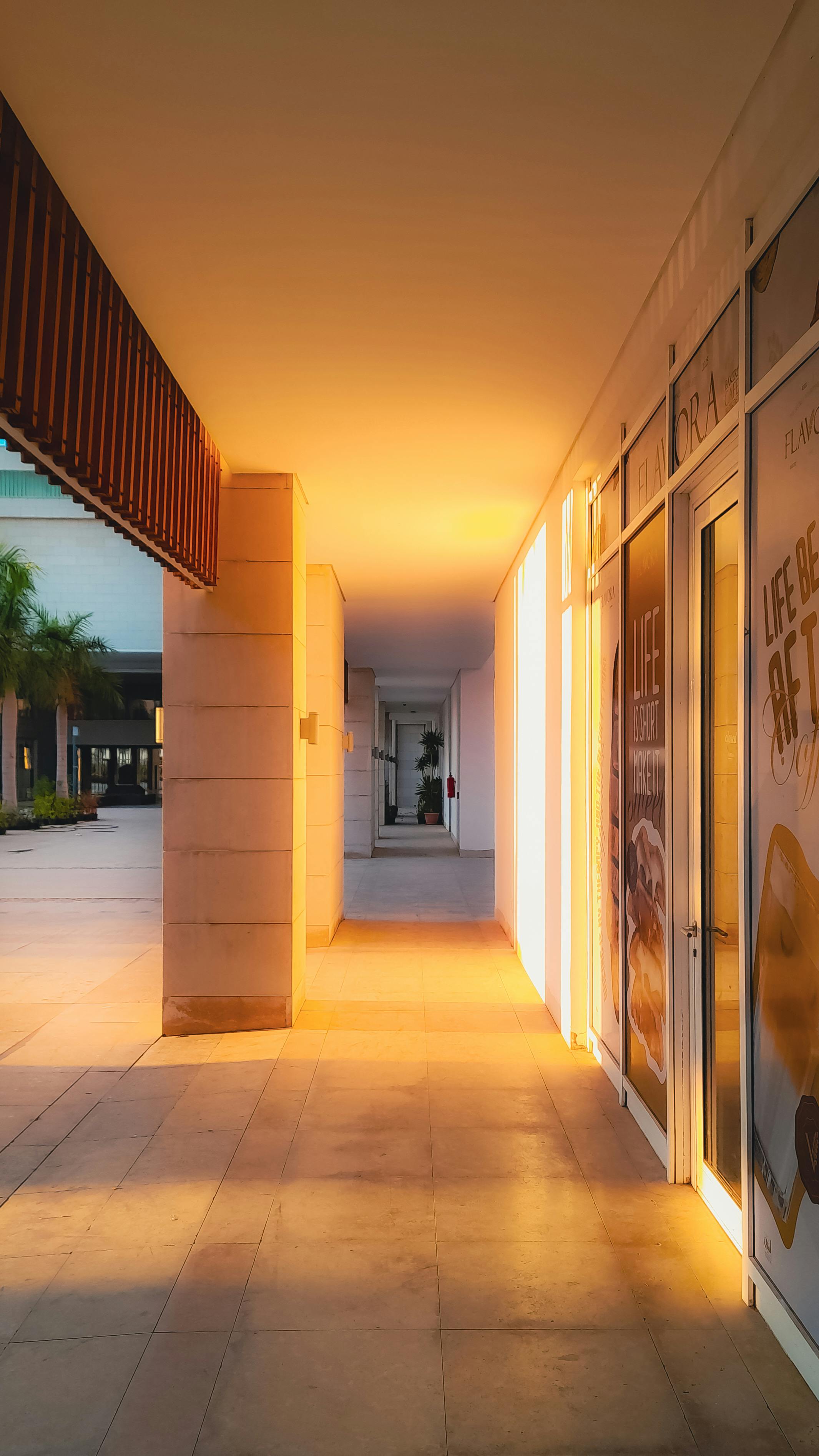 gratis Een stille gang, verlicht door het gouden zonlicht van het avonduur, creëert een serene en uitnodigende sfeer. Stockfoto