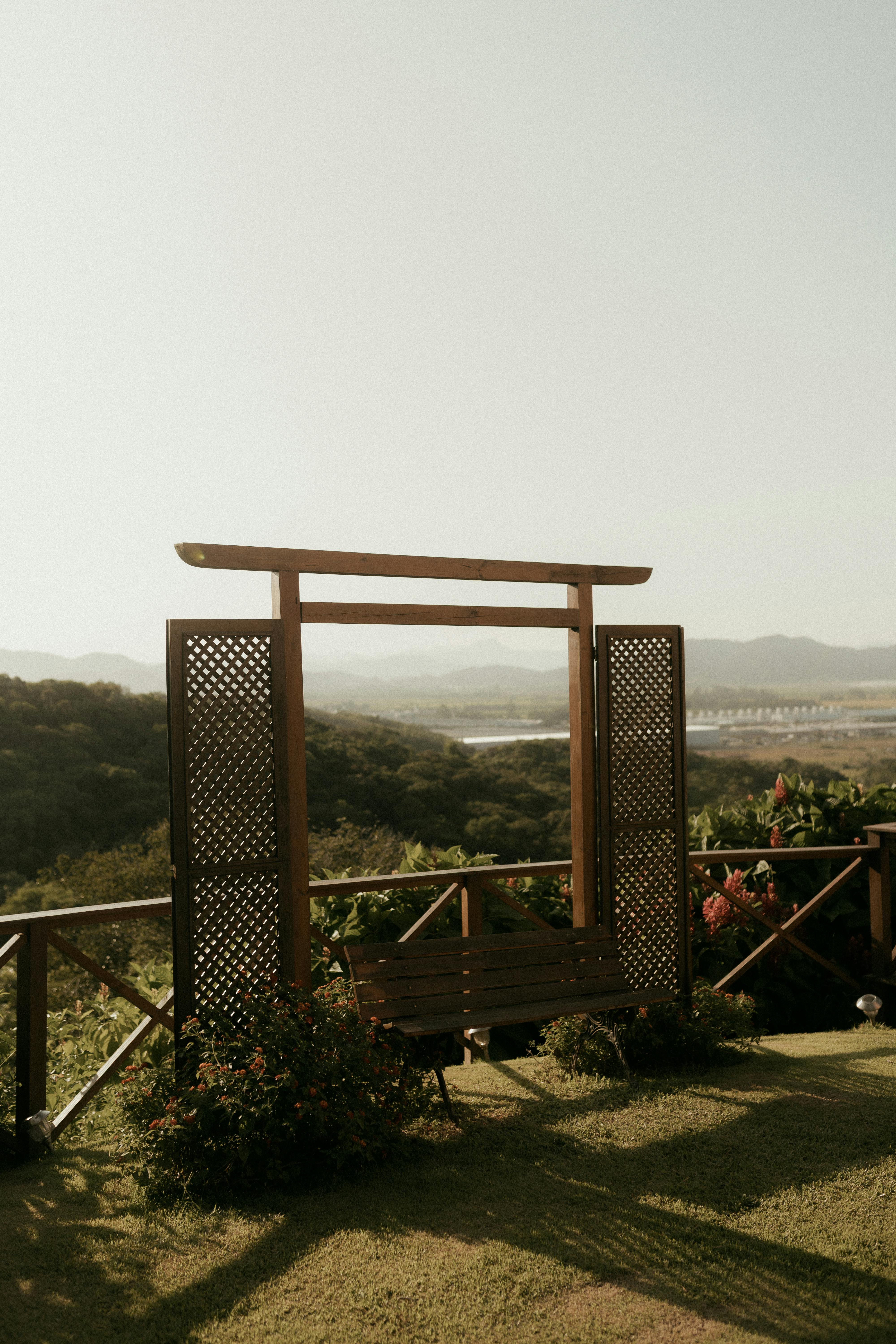 Gratis Una vista serena da un pergolato in legno su una valle lussureggiante sotto un cielo limpido. Foto a disposizione