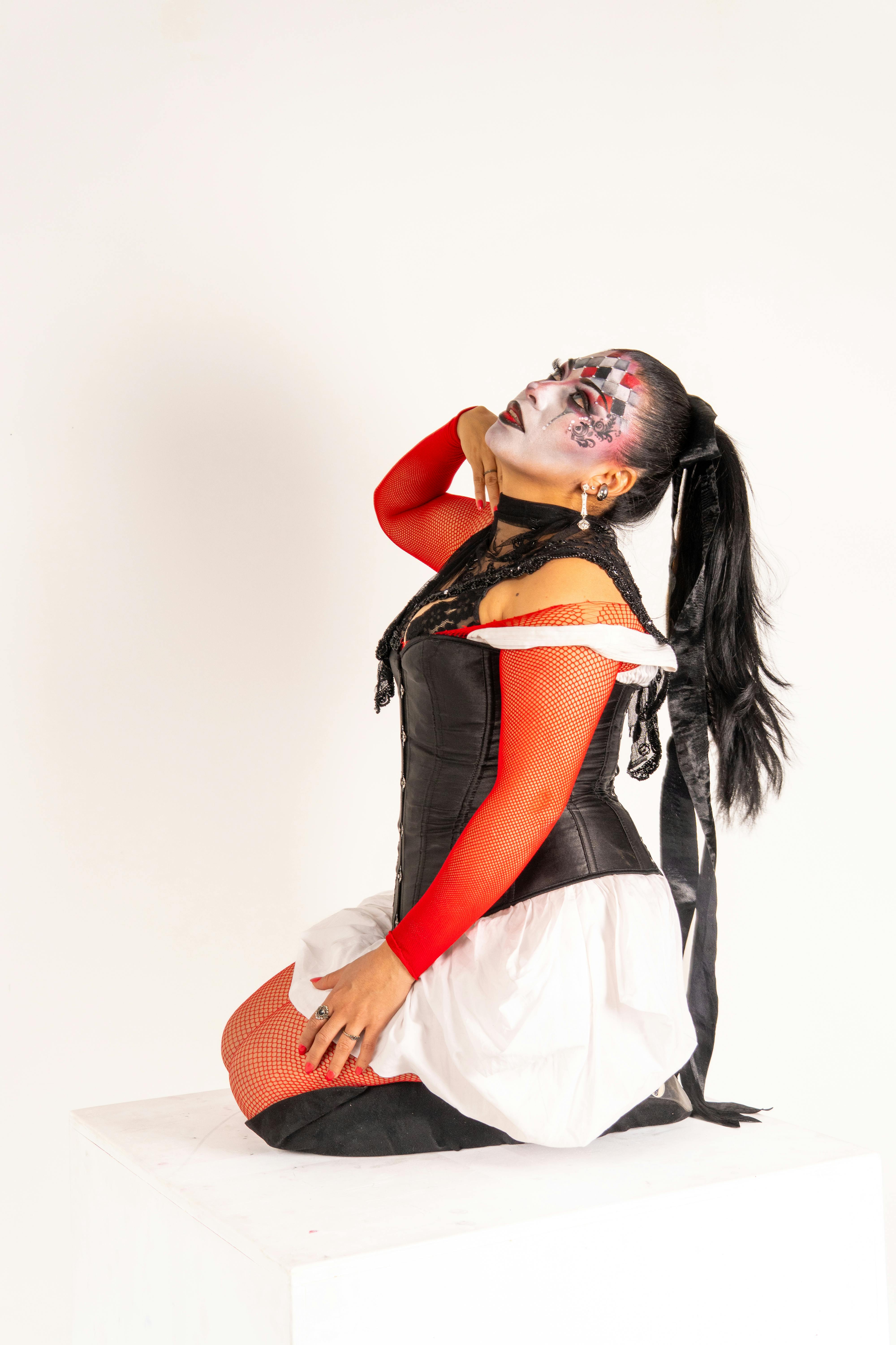 Gratis Ritratto artistico di una donna in costume da arlecchino con un trucco da clown unico. Foto a disposizione