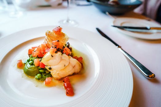 Elegant gourmet fish dish with peas and tomatoes, artfully plated. Perfect for cuisine enthusiasts.