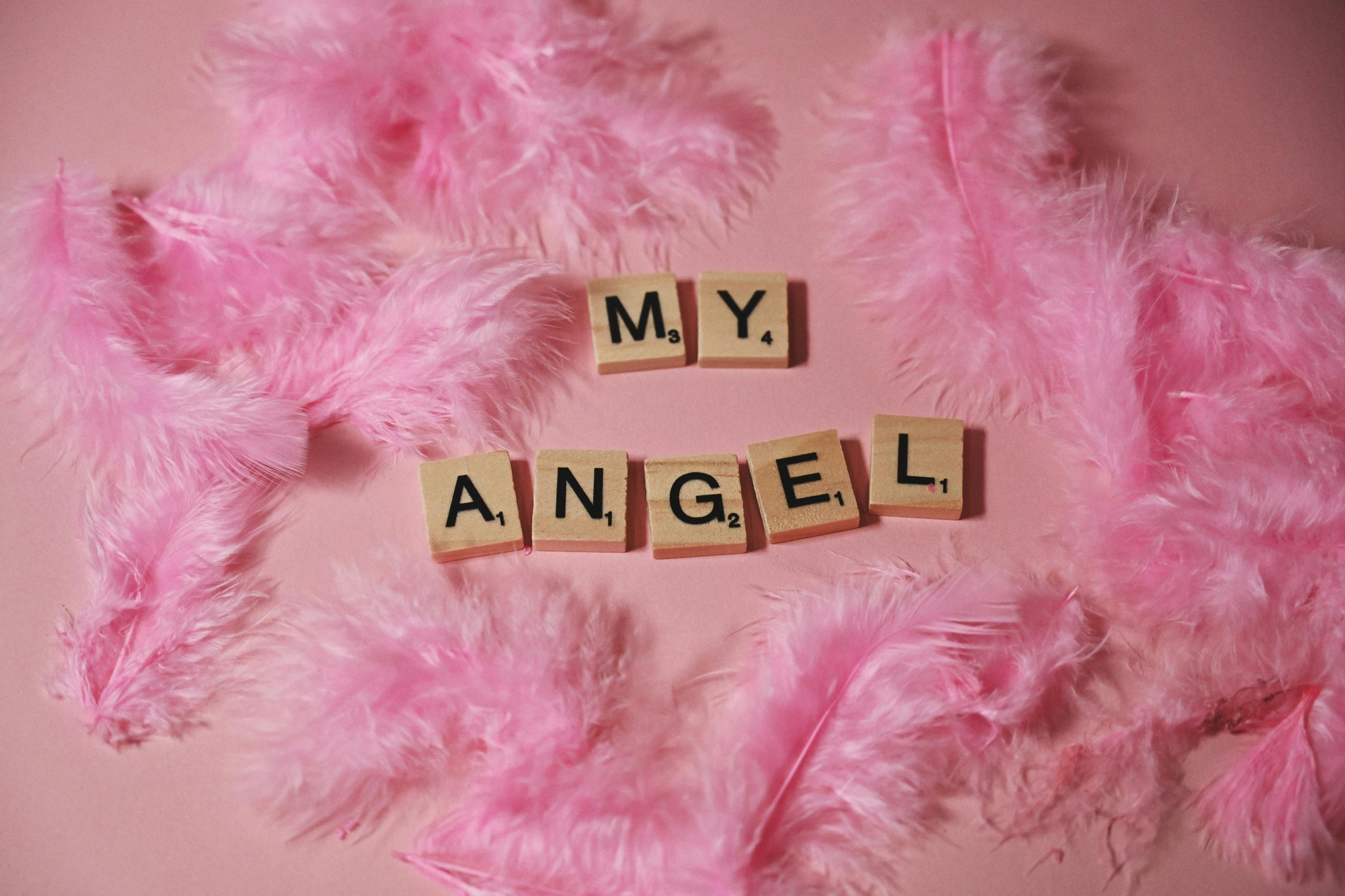 Δωρεάν Ροζ φτερά και πλακίδια Scrabble που γράφουν «My Angel» σε απαλό παστέλ φόντο. Φωτογραφία από στοκ φωτογραφιών