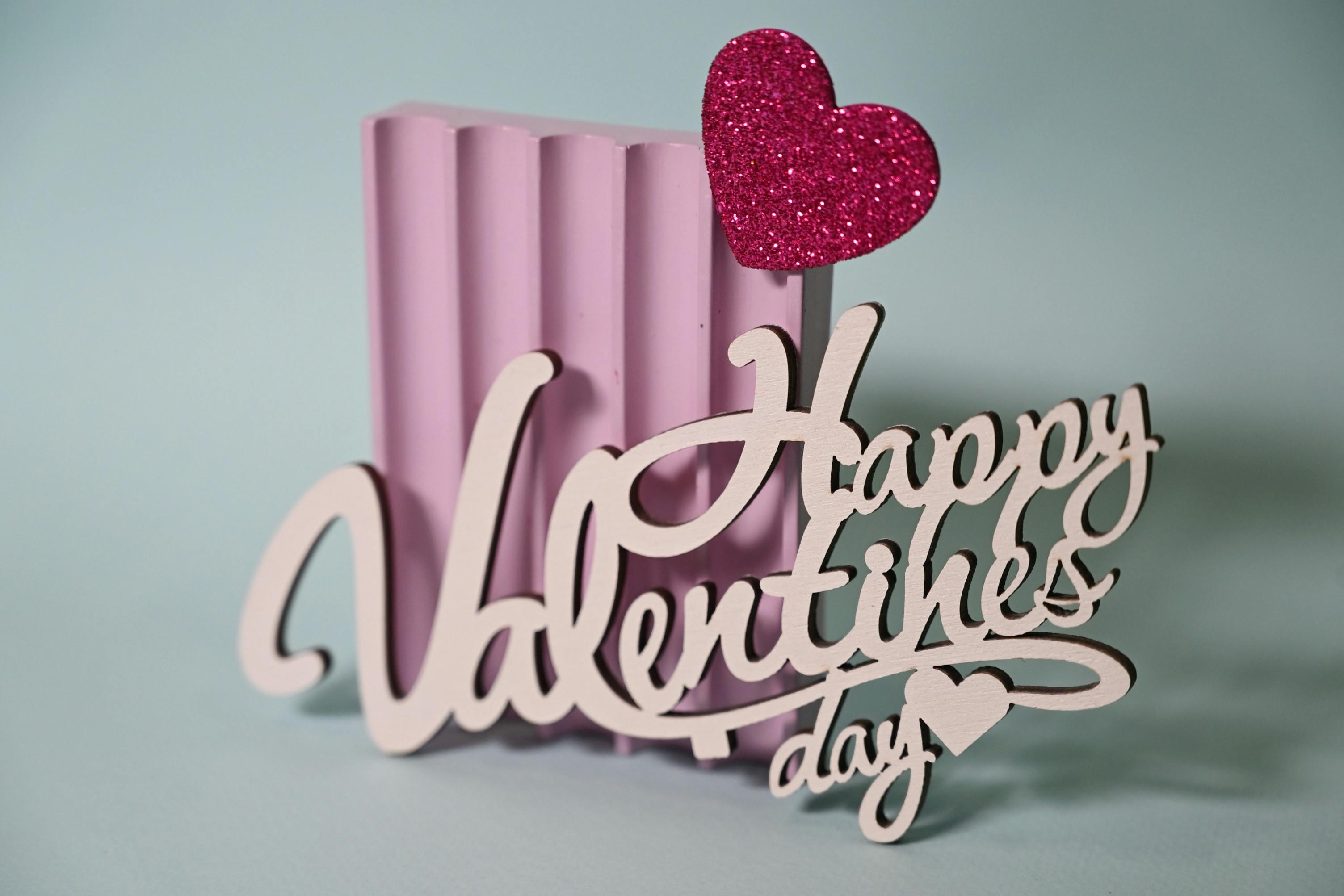 Romantic Valentine's Day decoration featuring pink heart and elegant typography.