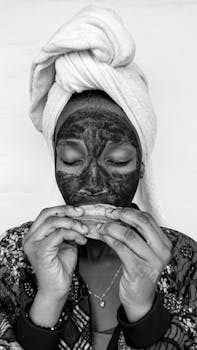 A woman enjoying a skincare ritual with a face mask at home.