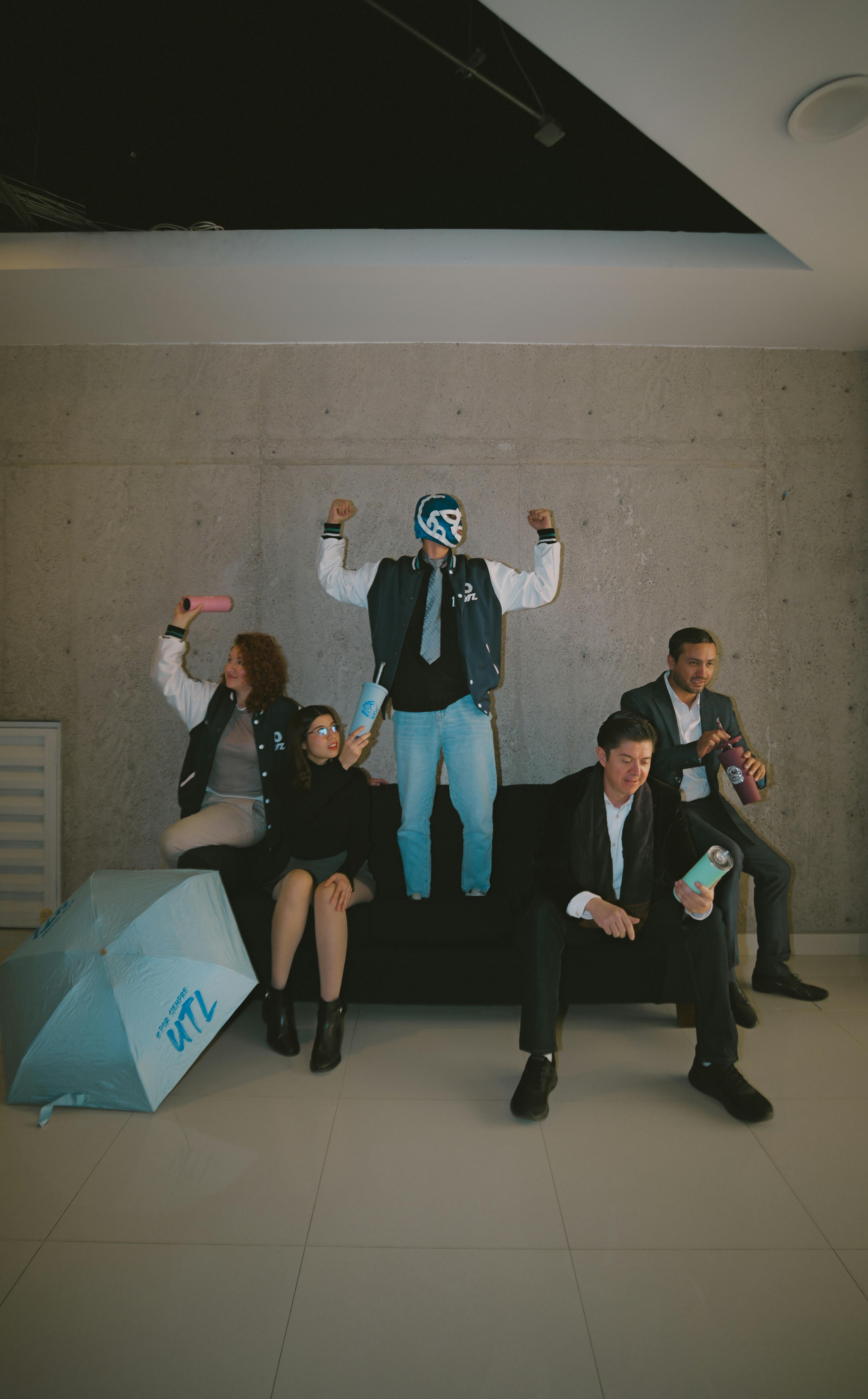 Gratuit Un groupe de collègues célèbre avec un lutteur dans un environnement de bureau, illustrant le travail d'équipe et la joie. Photos