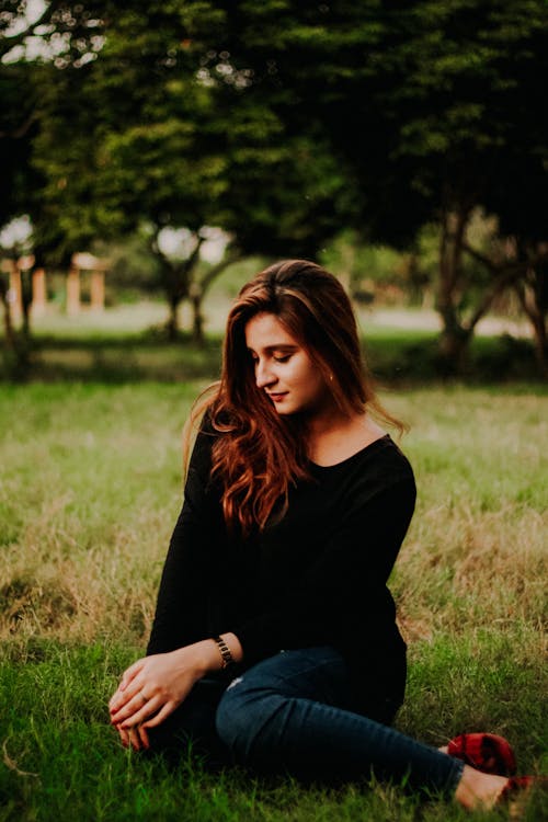 Woman Sitting on Grass Field