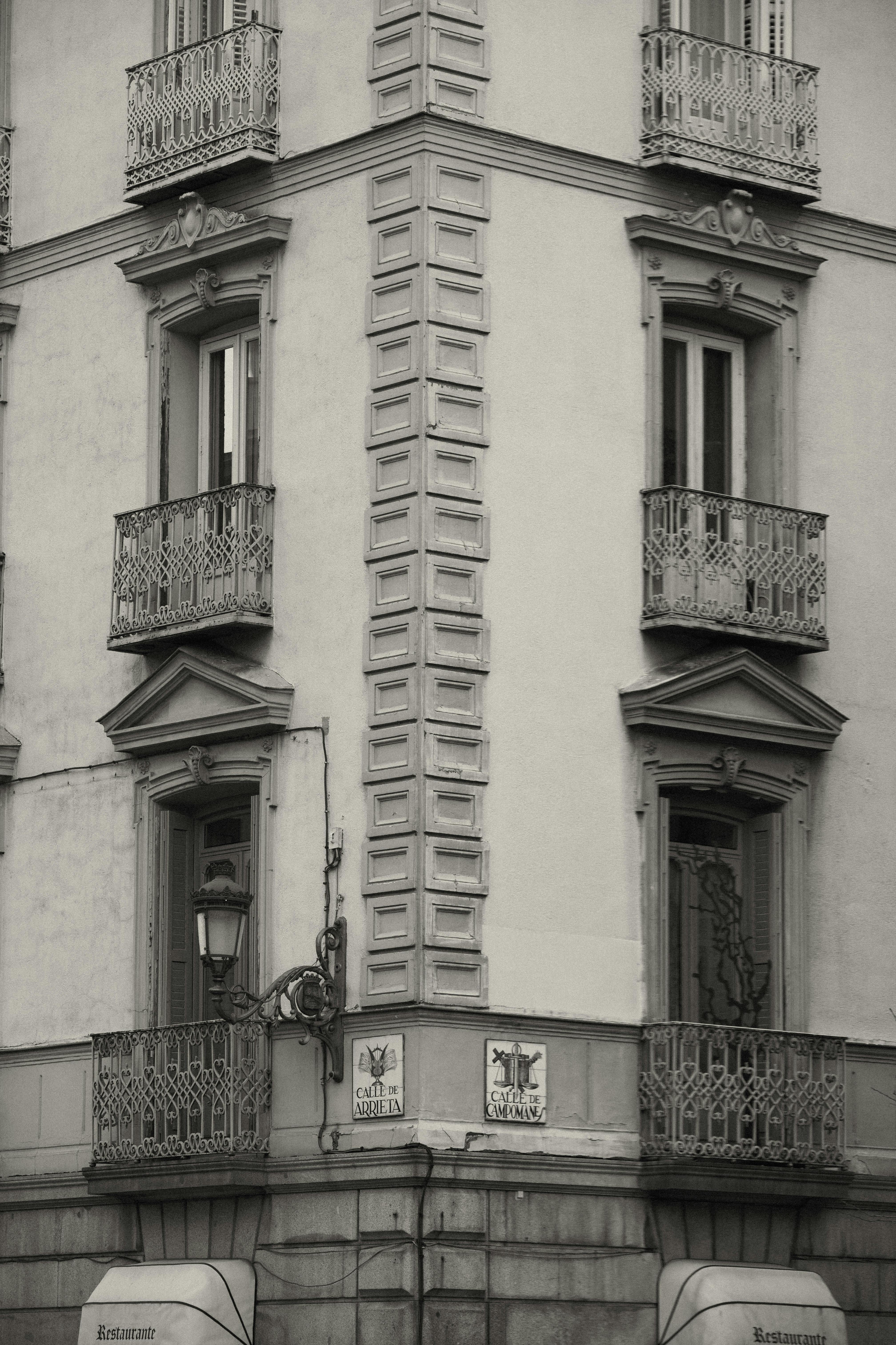 Gratis Sort-hvidt foto, der indfanger klassisk arkitektur i Madrid, med udsmykkede altaner og detaljeret facade. Lagerfoto