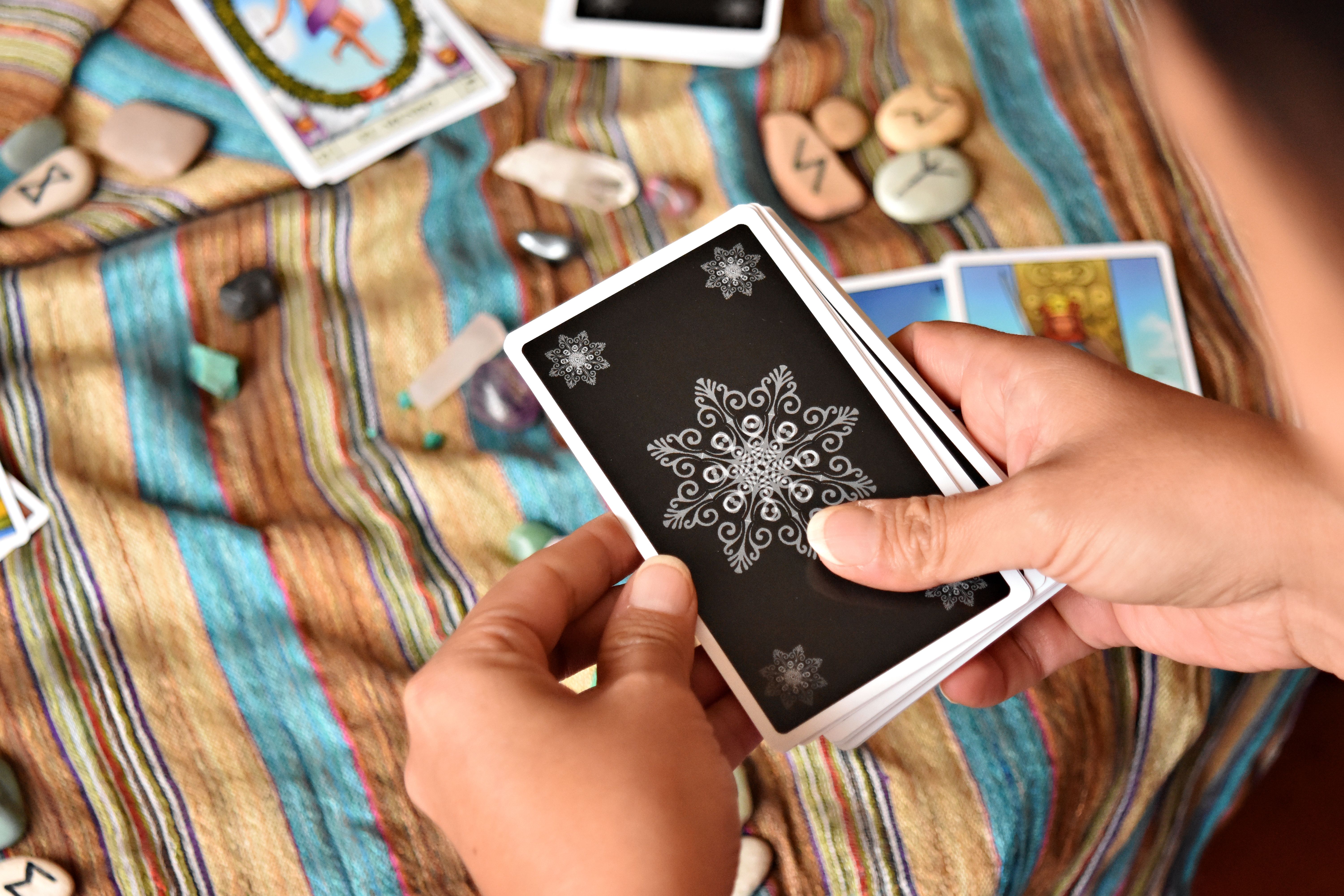 Hands Holding Tarot Cards on Striped Cloth · Free Stock Photo