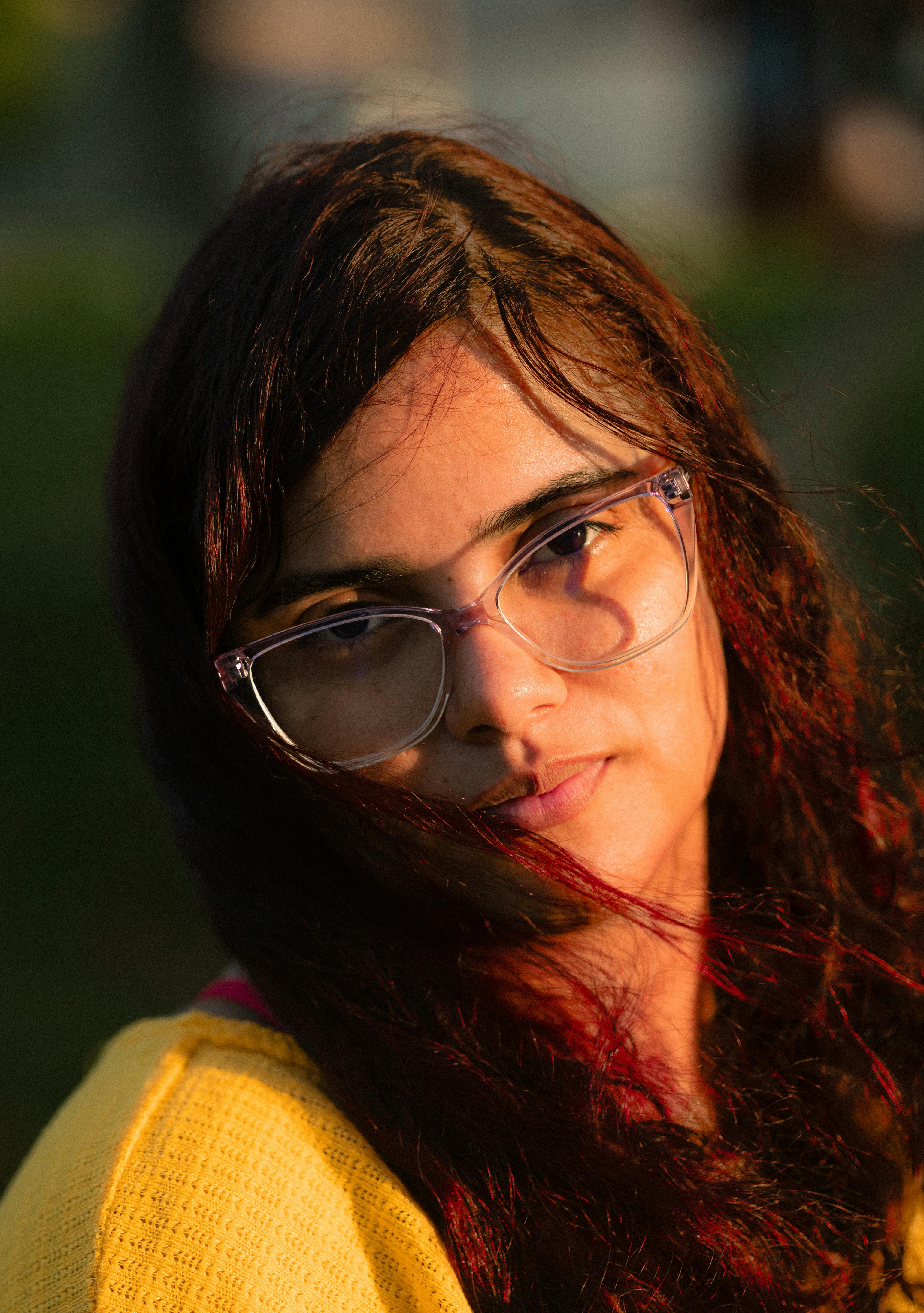 Gratis Affascinante ritratto all'aperto di una giovane donna durante l'ora d'oro, che mette in risalto la bellezza naturale. Foto a disposizione