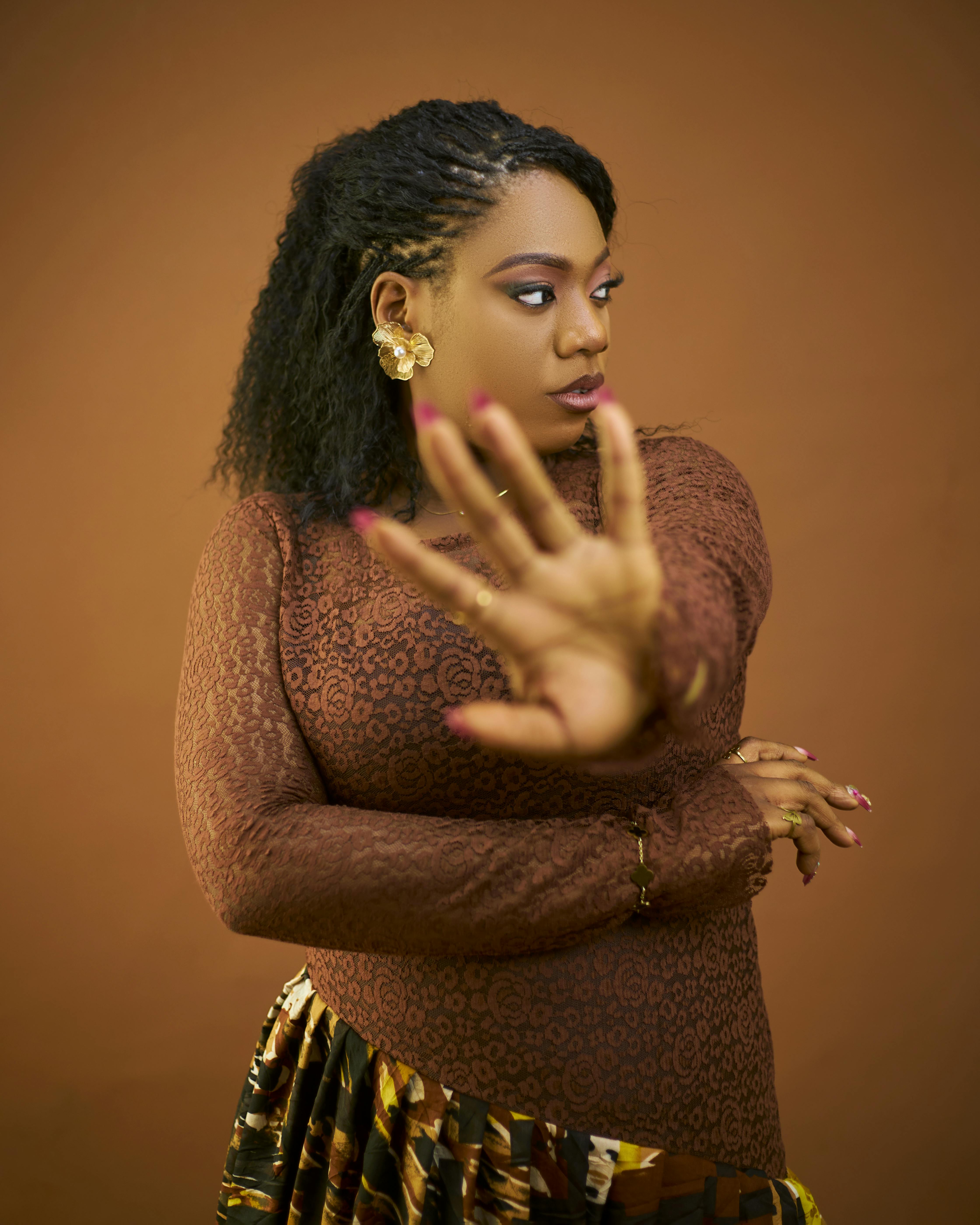 ingyenes Magabiztos nő pózol kézmozdulattal élénk háttér előtt. Stockfotó