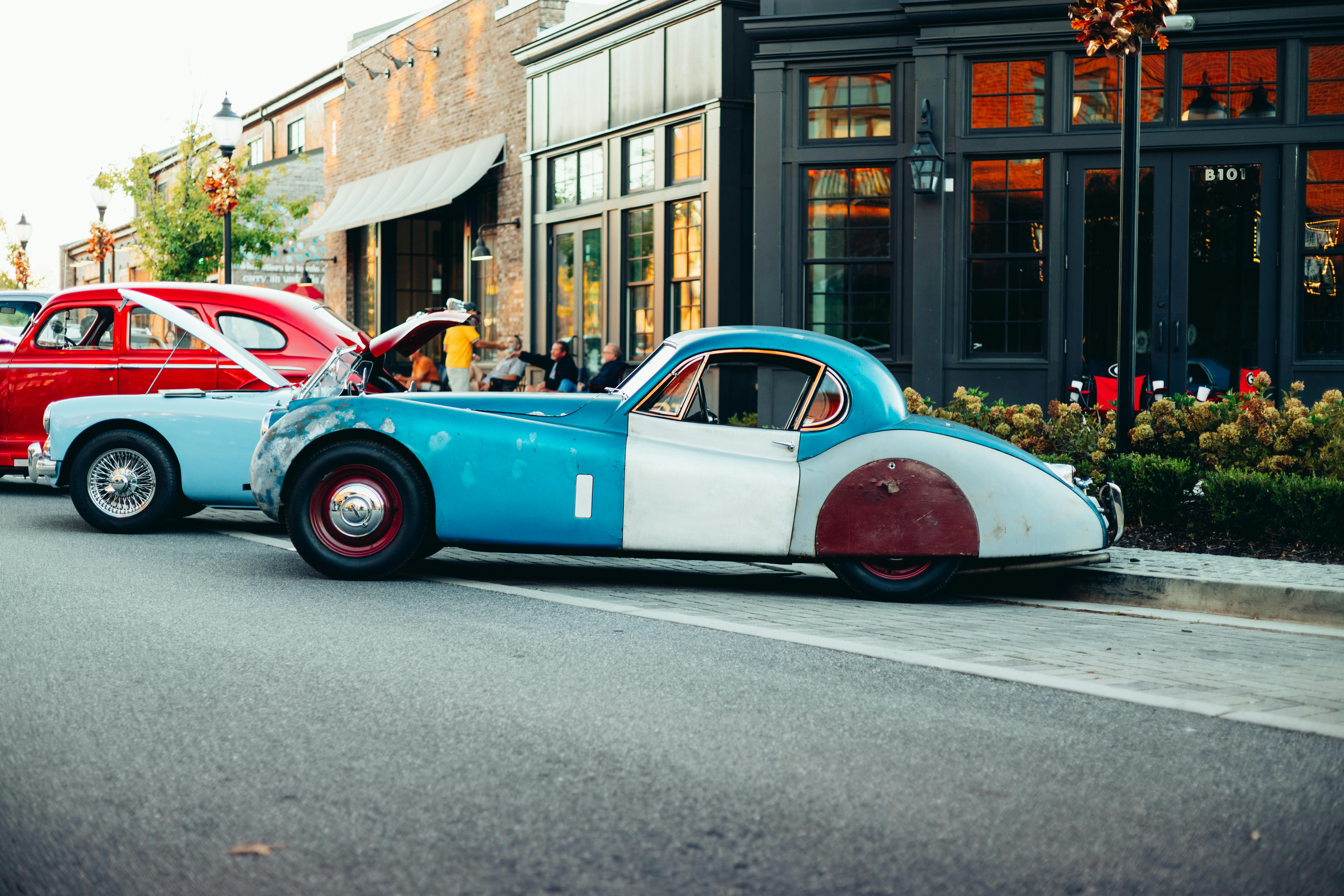 ingyenes Egy élénk jelenet klasszikus autókról, amelyek egy bájos városi utcán parkolnak nappal. Stockfotó