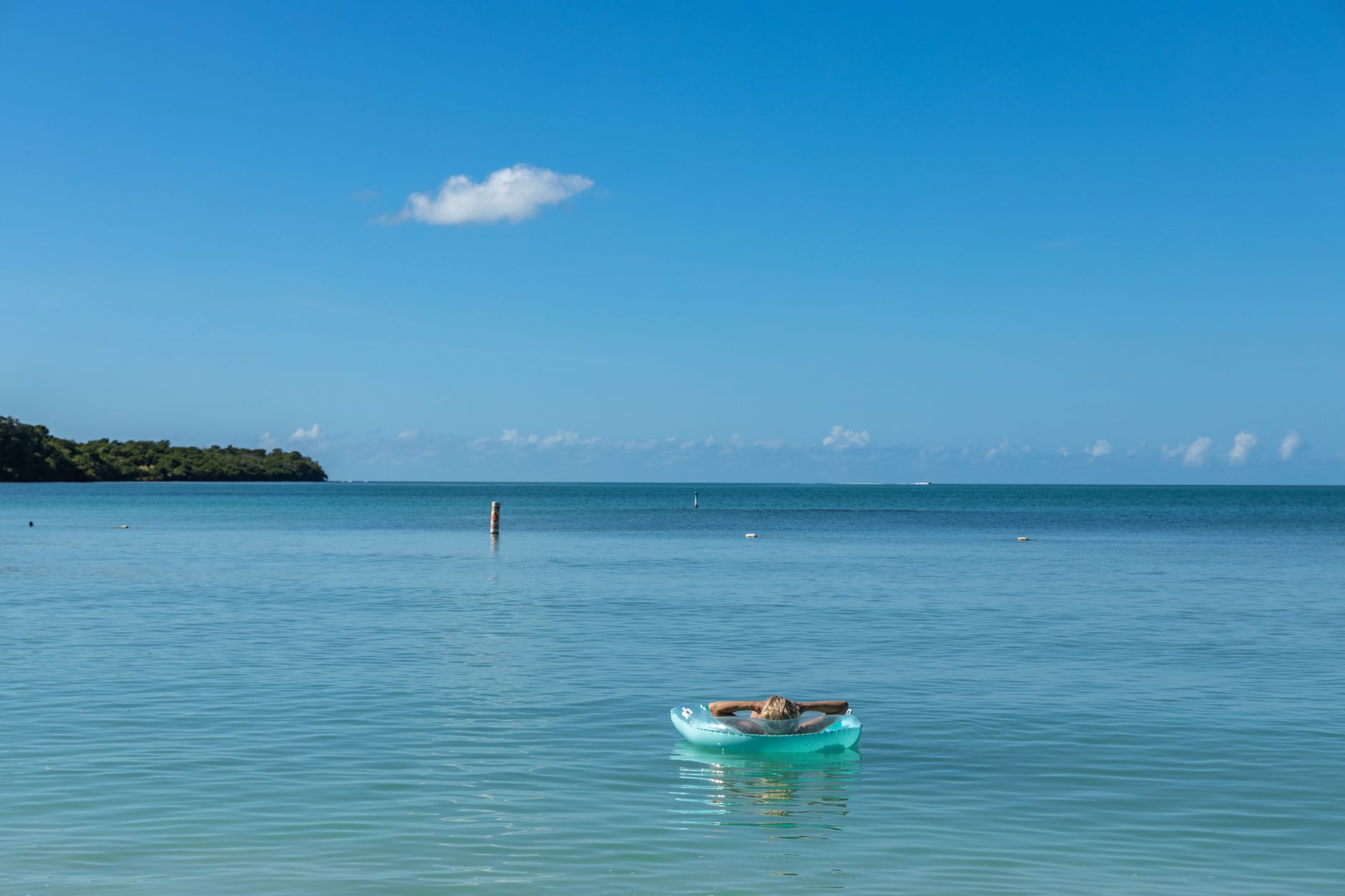 Peaceful ocean scene with a woman relaxing in a buoy at Cabo Rojo, Puerto Rico.