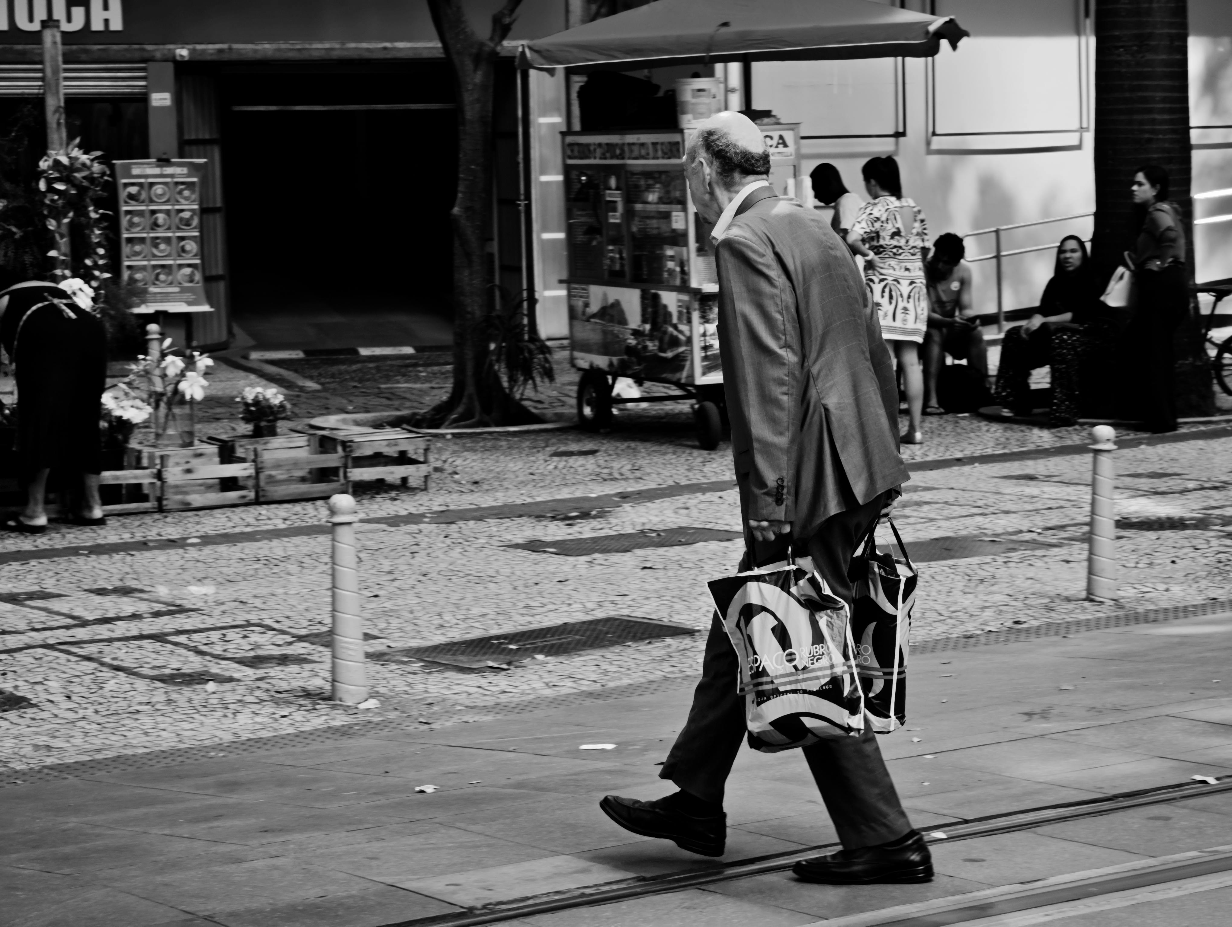 Gratis Foto in bianco e nero di un uomo anziano che cammina per una strada a Rio de Janeiro, Brasile. Foto a disposizione