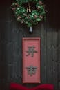 Festive Wreath and Red Signboard on Dark Wood Wall