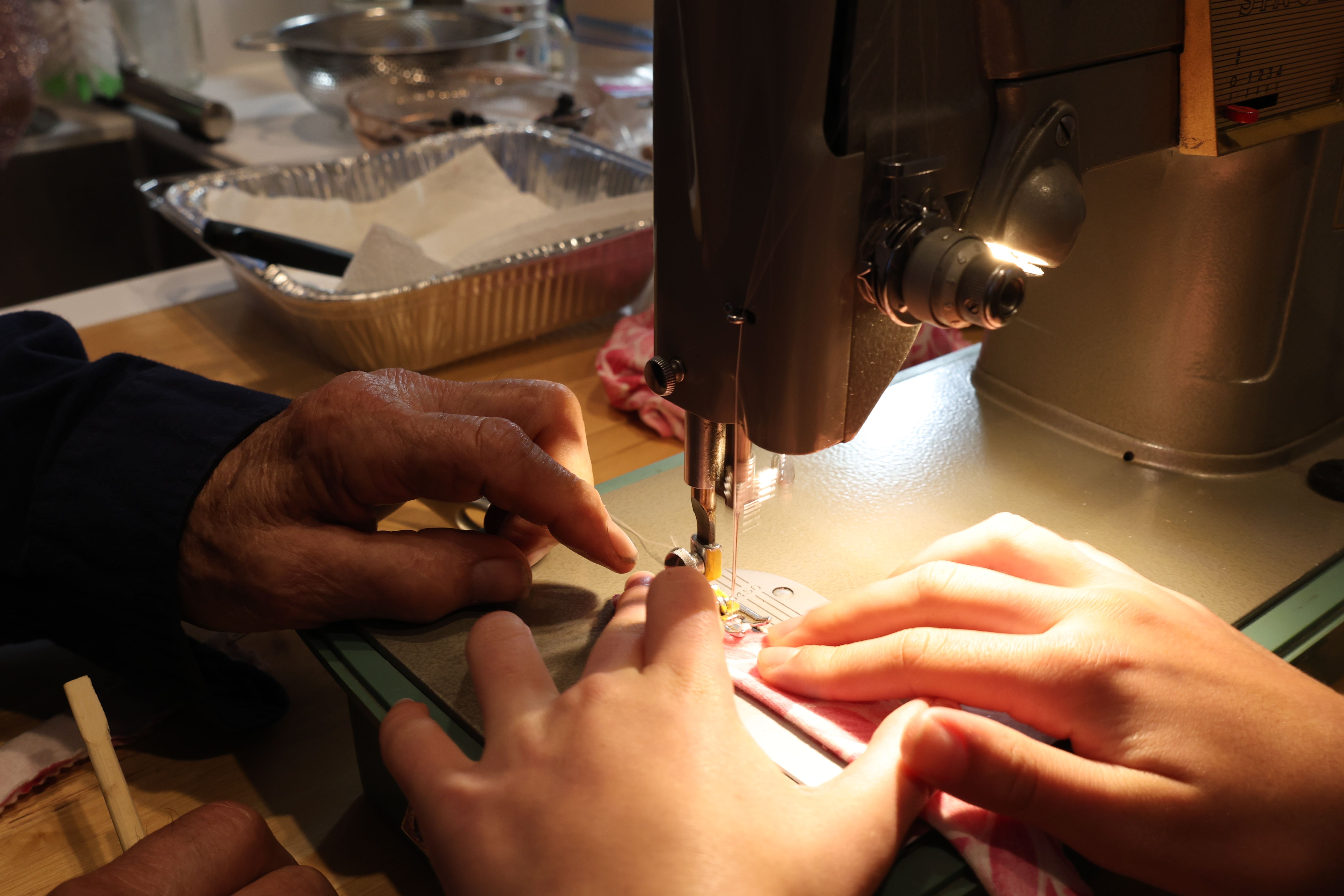 Hands of different ages working together on a vintage sewing machine, highlighting craftsmanship. — Maynard Longarm Quilting