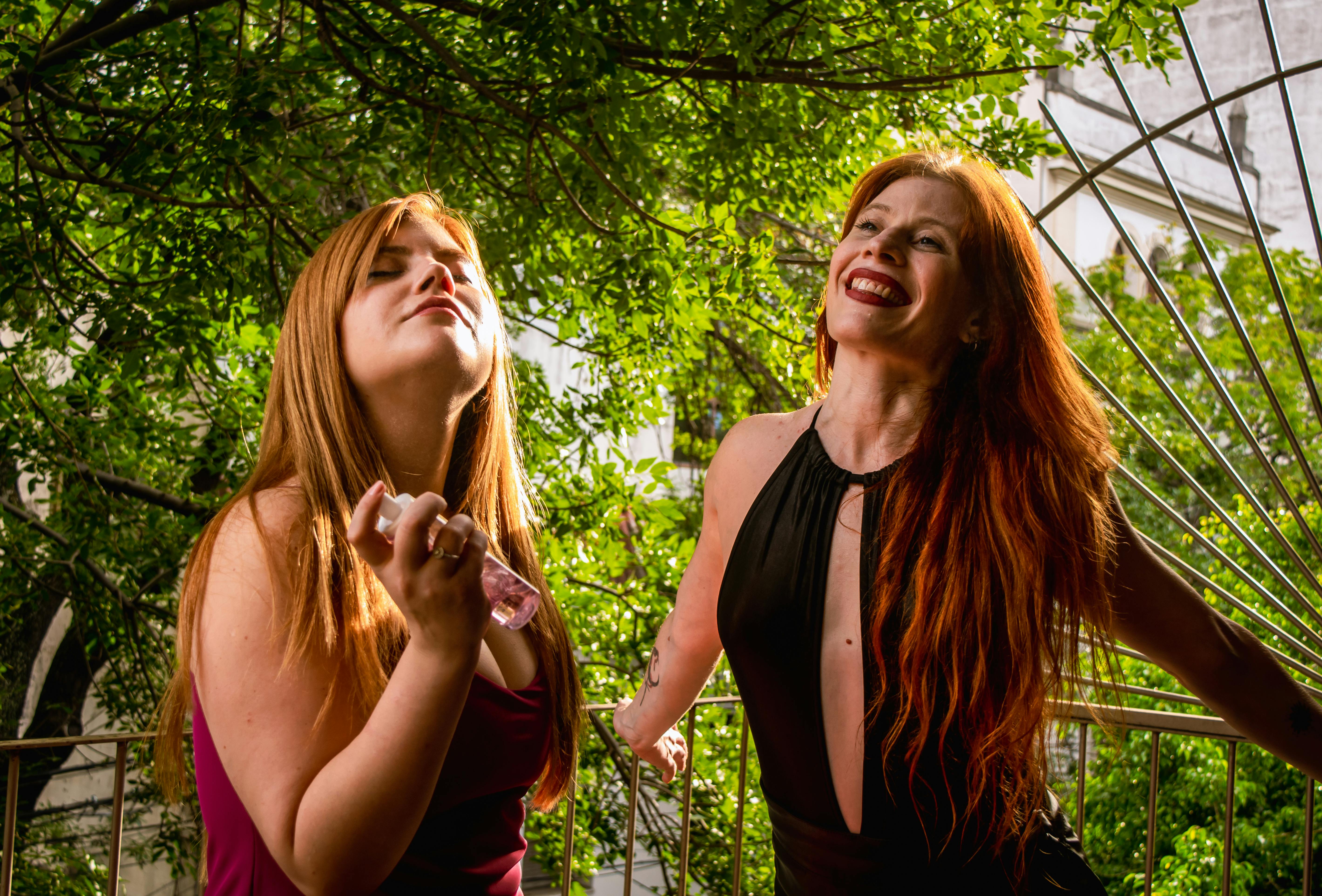 gratis Twee vrouwen genieten van een zonnige dag in de buitenlucht, zich koesterend in de zon met een glimlach en volkomen ontspannen. Stockfoto