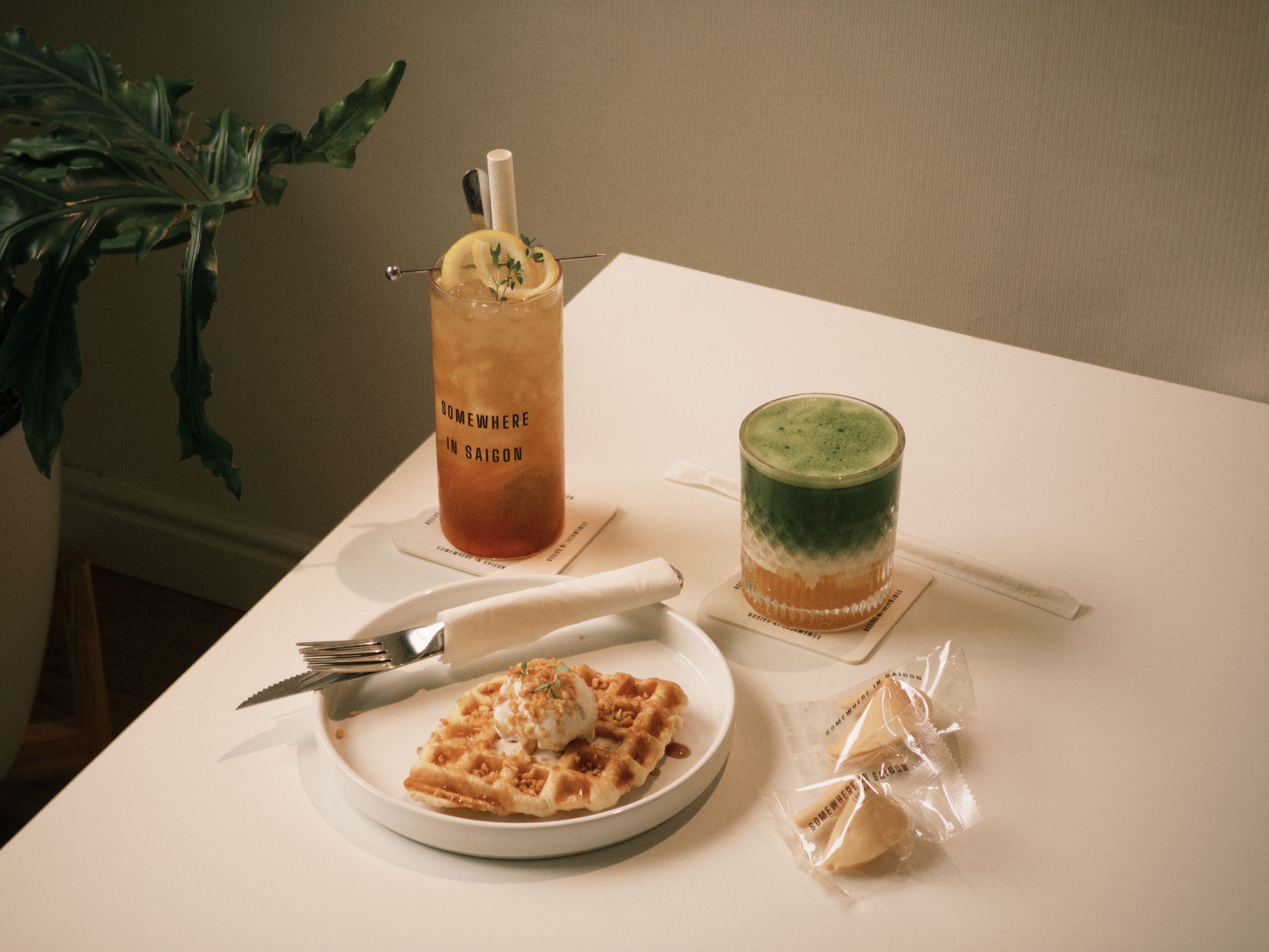 Trendy cafe scene featuring a waffle, fortune cookies, and beverages, captured with a modern aesthetic.