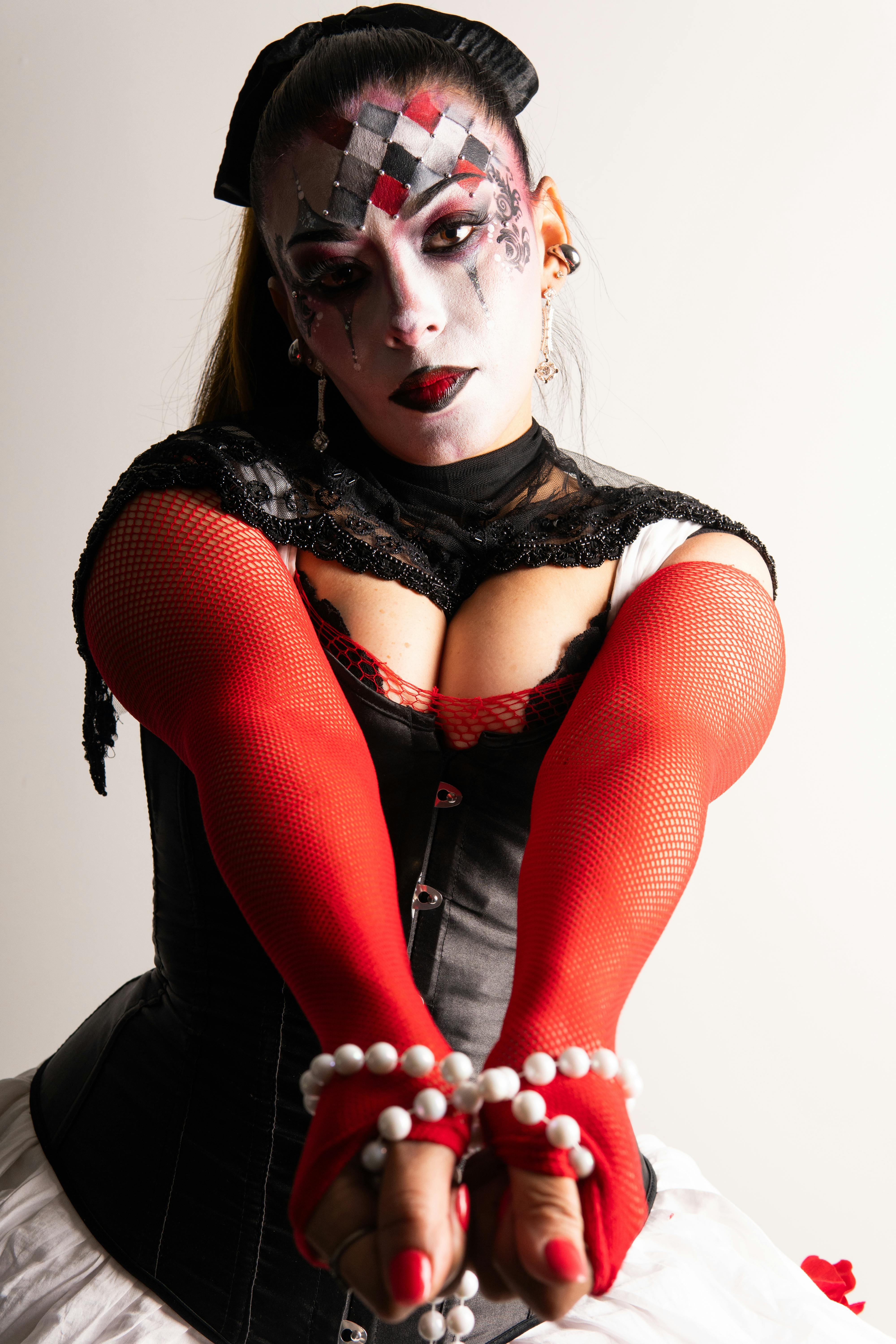 gratis Vrouw in een Harley Quinn-achtig kostuum met opvallende make-up en rode handschoenen. Stockfoto