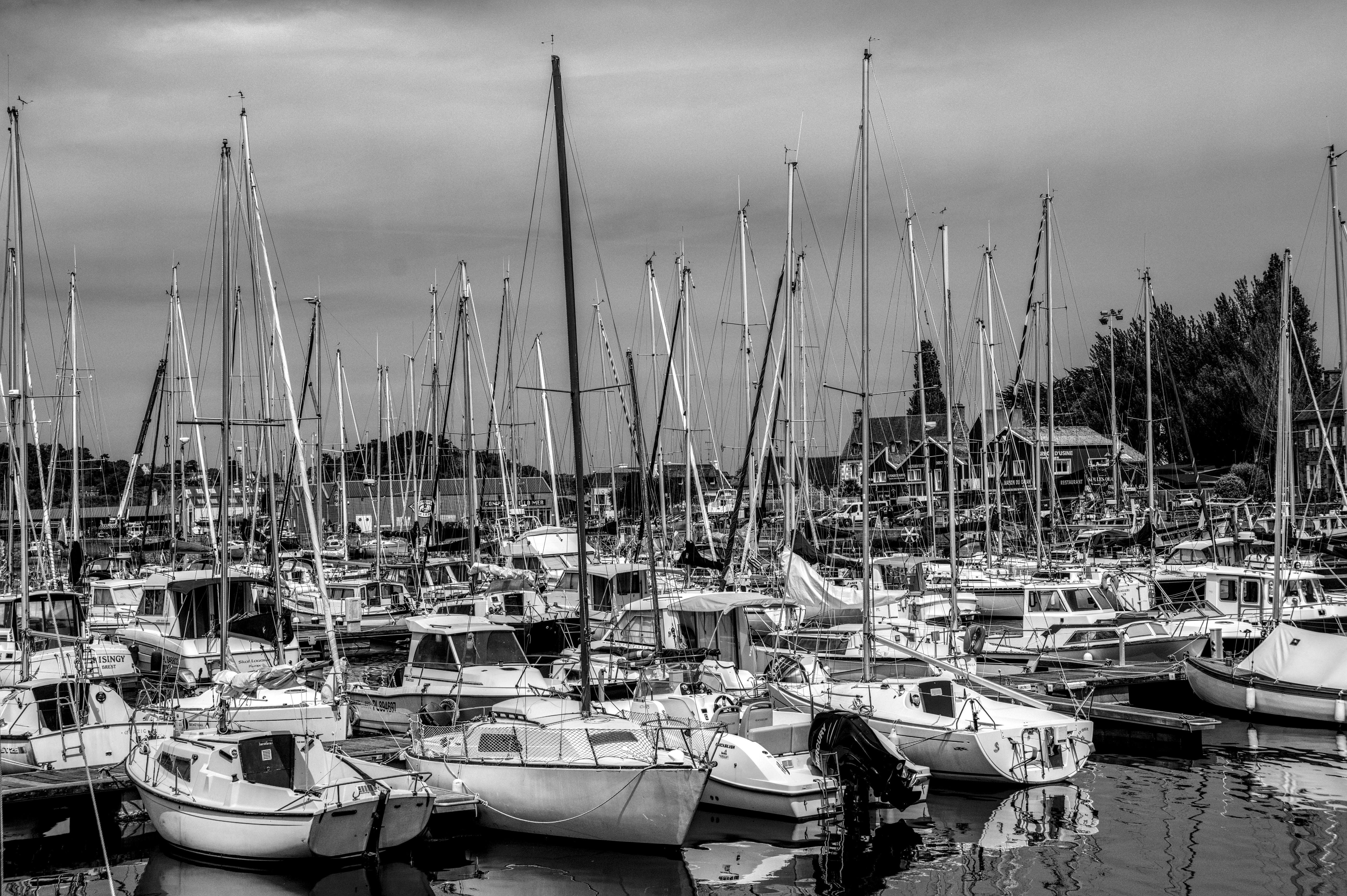 ingyenes Egy fekete-fehér kép több jachtról, amelyek egy festői kikötőben horgonyoznak Bretagne-ban, Franciaországban. Stockfotó