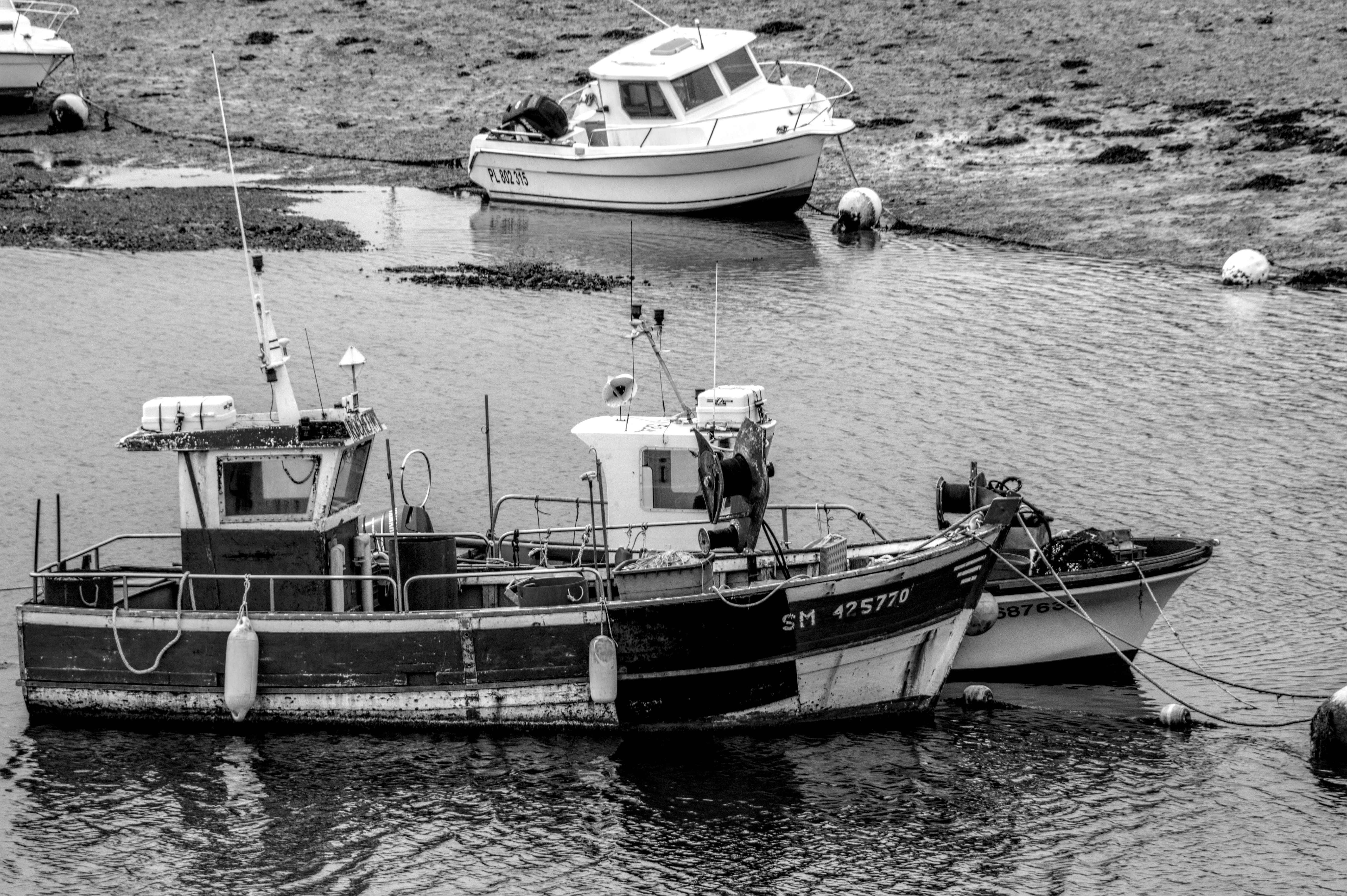 Monochrome view of fishing boats at low tide on Brittany's coastline.