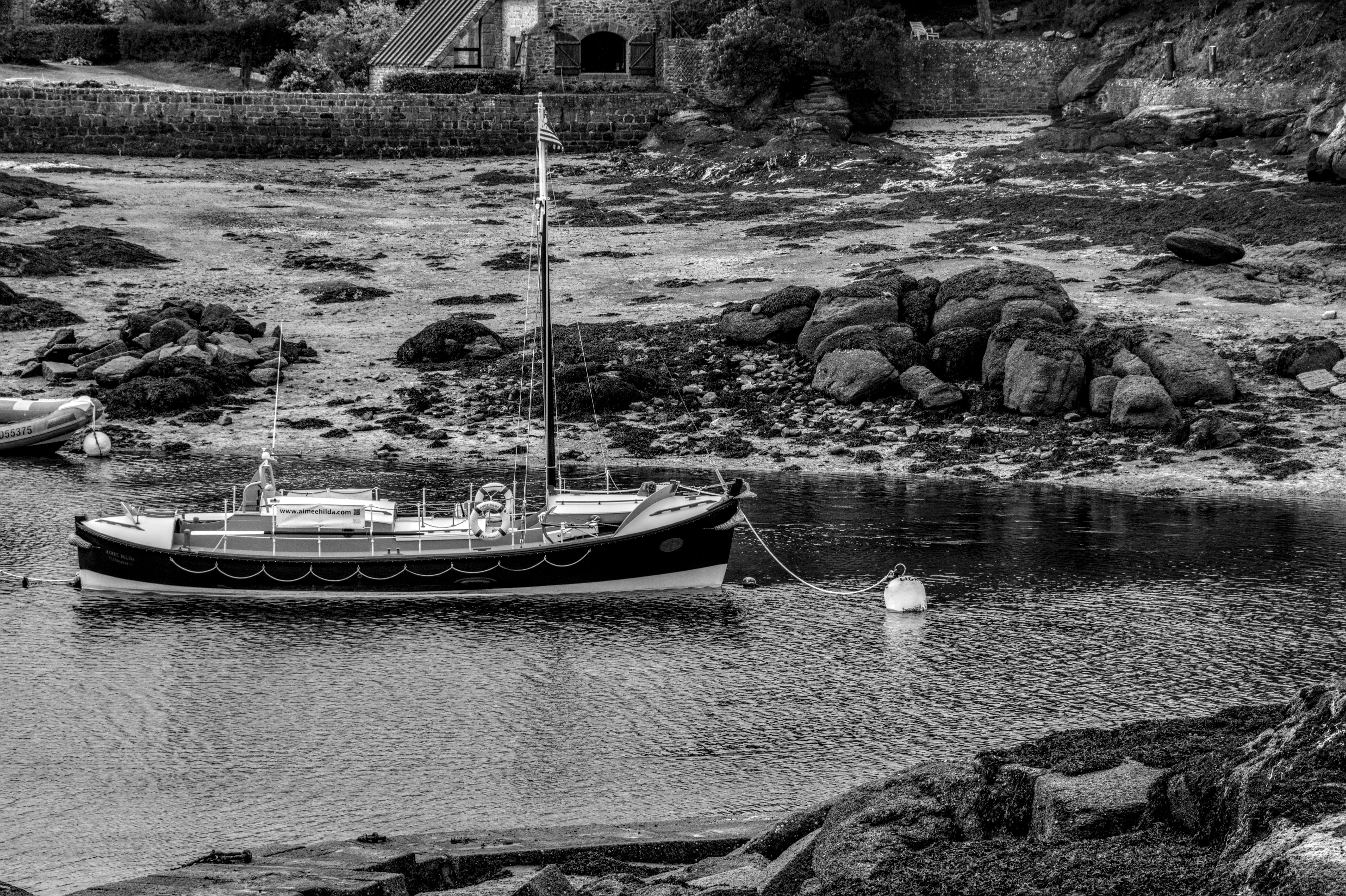 Δωρεάν Γαλήνια ασπρόμαυρη εικόνα ενός σκάφους αγκυροβολημένου σε βραχώδες παράκτιο περιβάλλον στη Βρετάνη της Γαλλίας. Φωτογραφία από στοκ φωτογραφιών