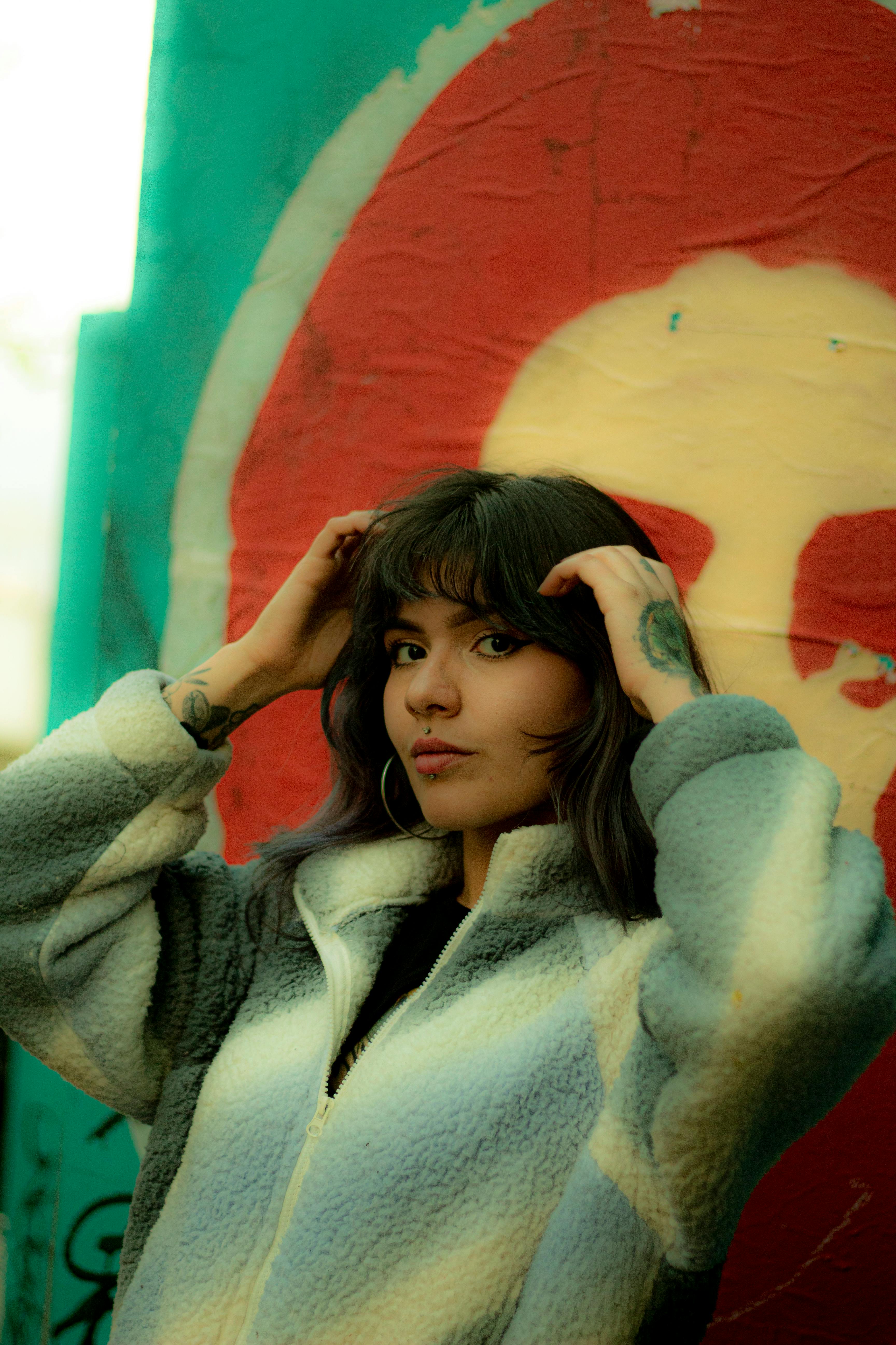 Δωρεάν Κομψή γυναίκα ποζάρει με φόντο ζωηρό γκράφιτι σε αστικό περιβάλλον. Φωτογραφία από στοκ φωτογραφιών