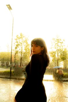 A young woman standing in the rain with a thoughtful expression in Toluca de Lerdo, Mexico.