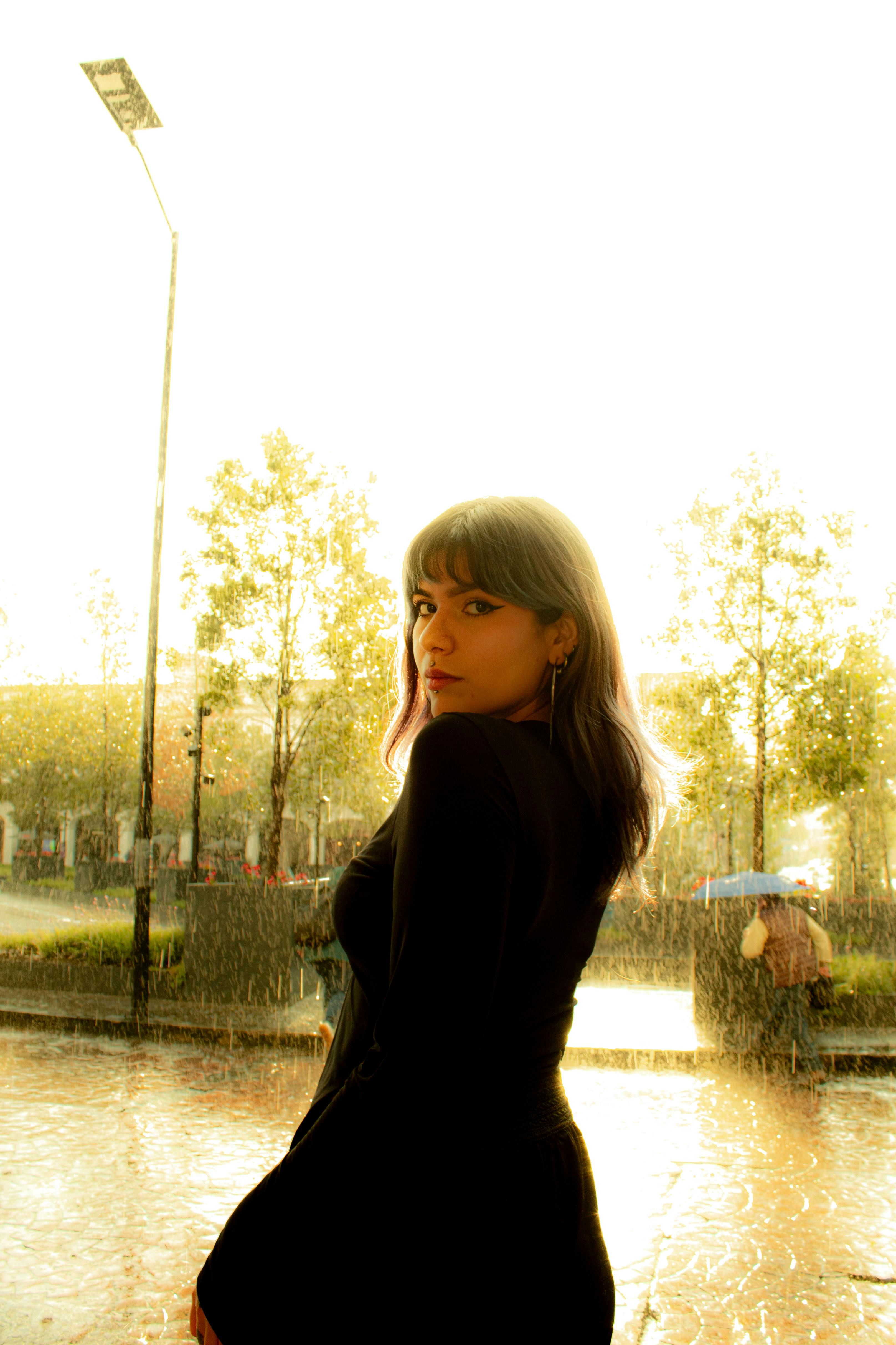 Gratis Una giovane donna in piedi sotto la pioggia con un'espressione pensierosa a Toluca de Lerdo, in Messico. Foto a disposizione