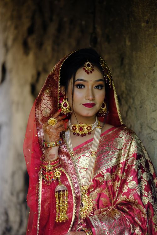 Free Beautiful bride in ornate red and gold traditional attire with intricate jewelry. Stock Photo