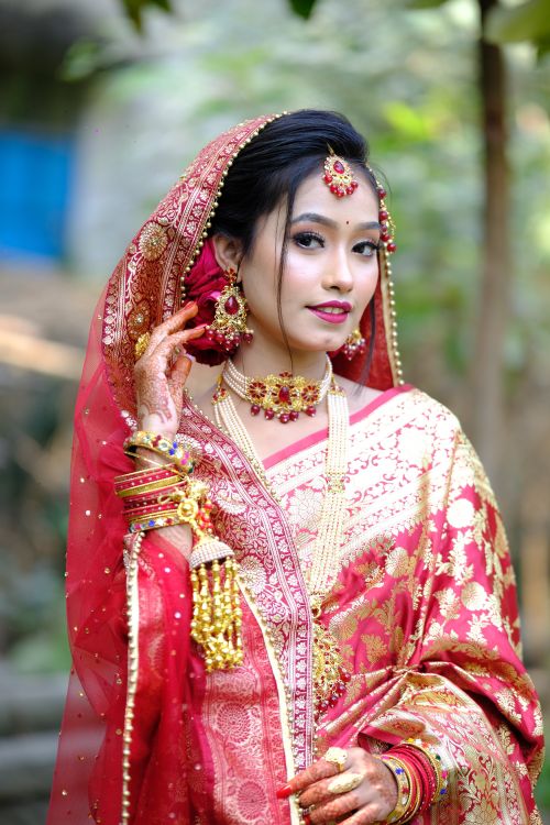 Free A stunning portrait of a bride in traditional attire, showcasing intricate jewelry and vibrant textiles. Stock Photo