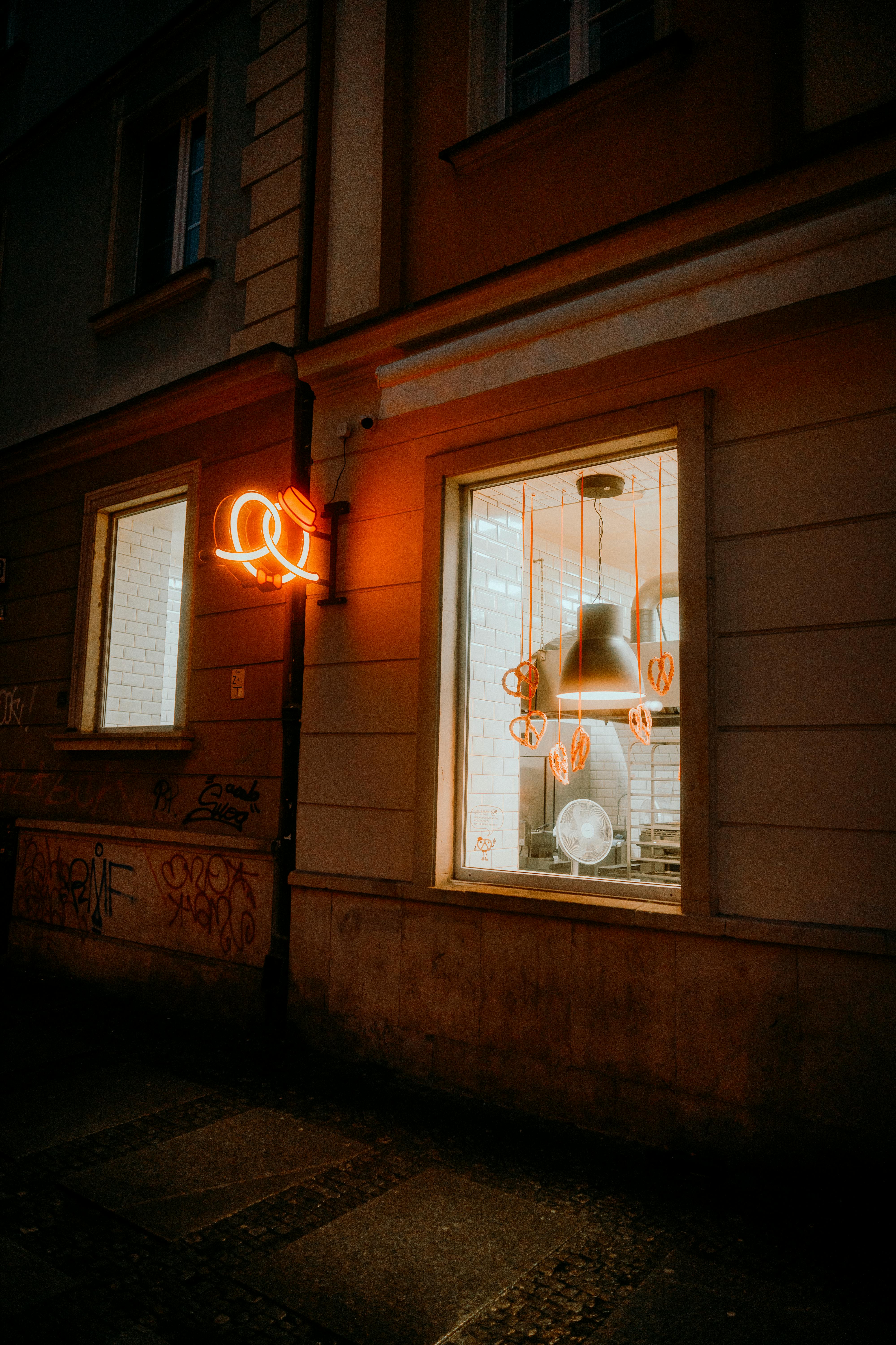 Gratis Pemandangan jalanan yang diterangi lampu neon di malam hari, menampilkan etalase toko Breslau yang nyaman. Foto Stok